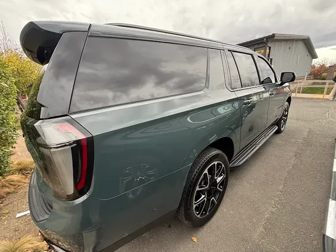 Green SUV indoors with window tint film, showcasing privacy and aesthetics. 