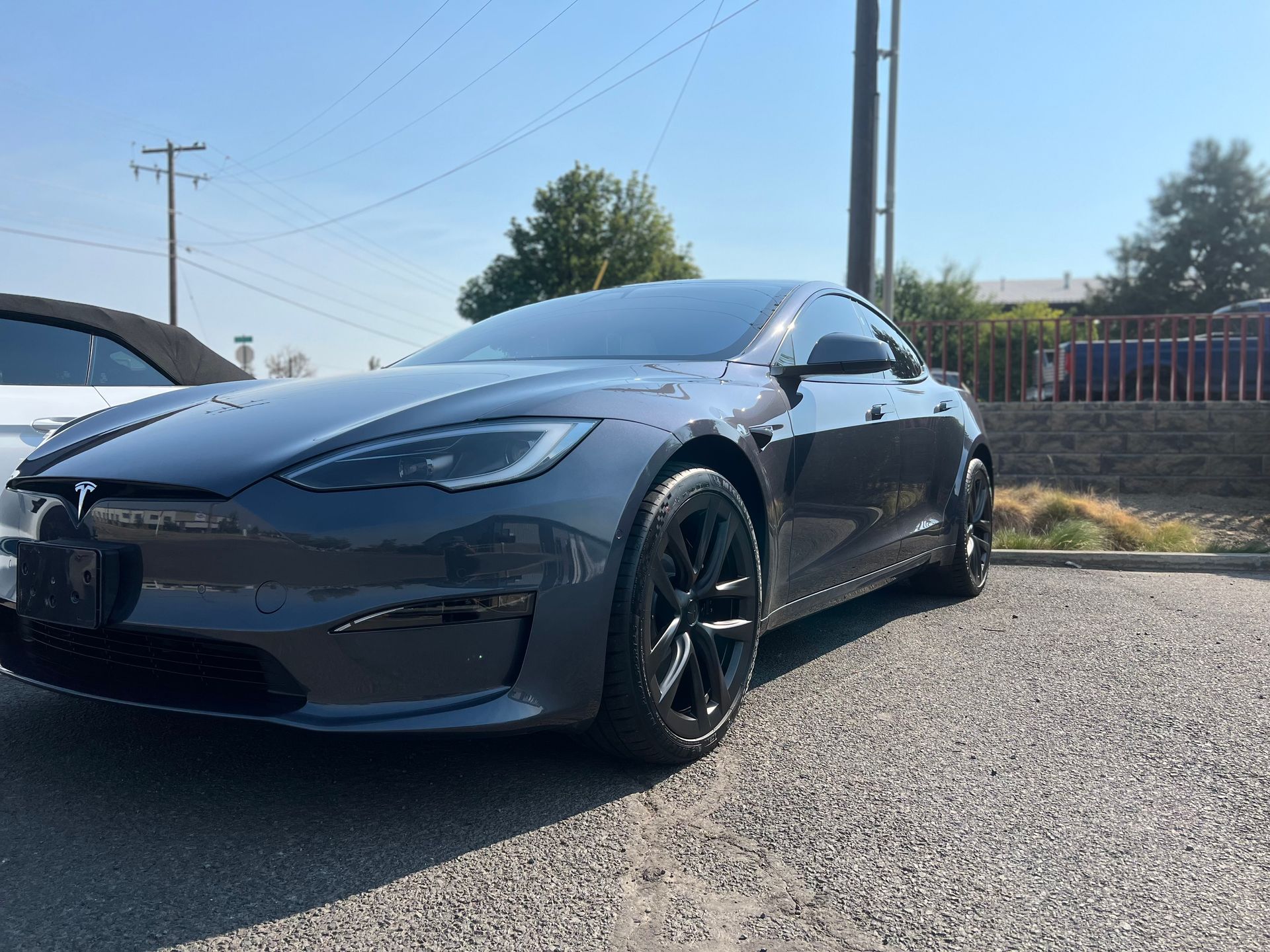 A tesla model s is parked on the side of the road.