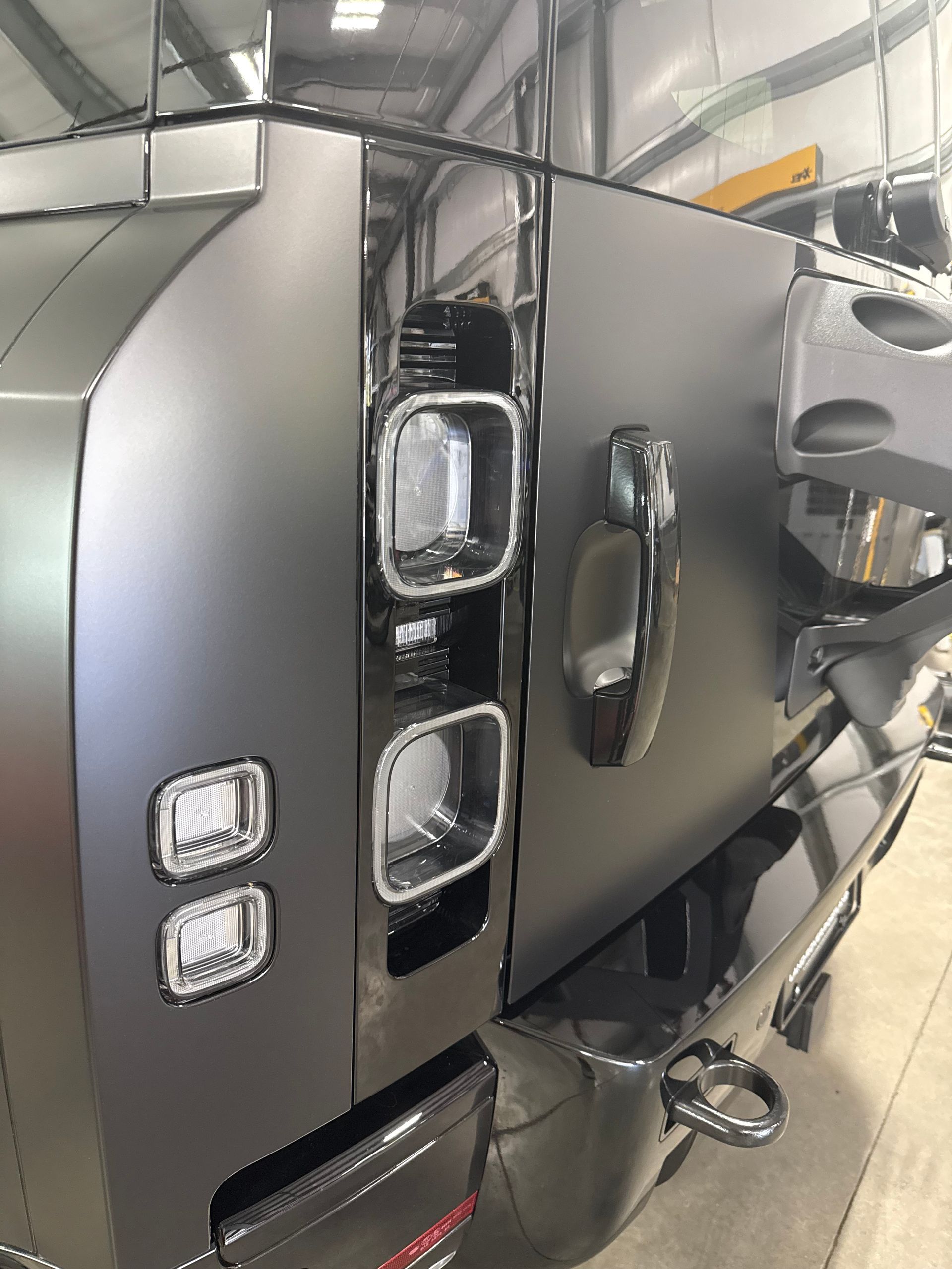 A black truck is parked in a garage.