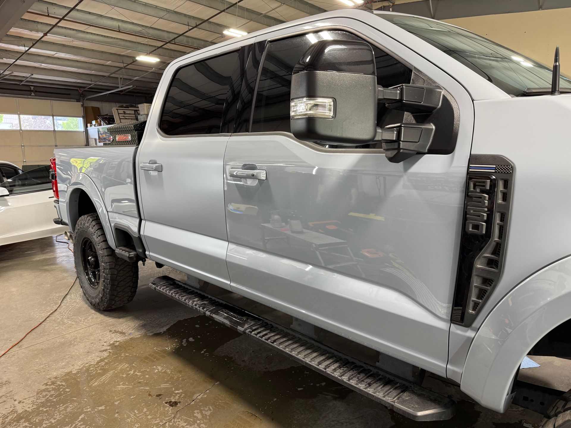 A gray pickup truck is parked in a garage.