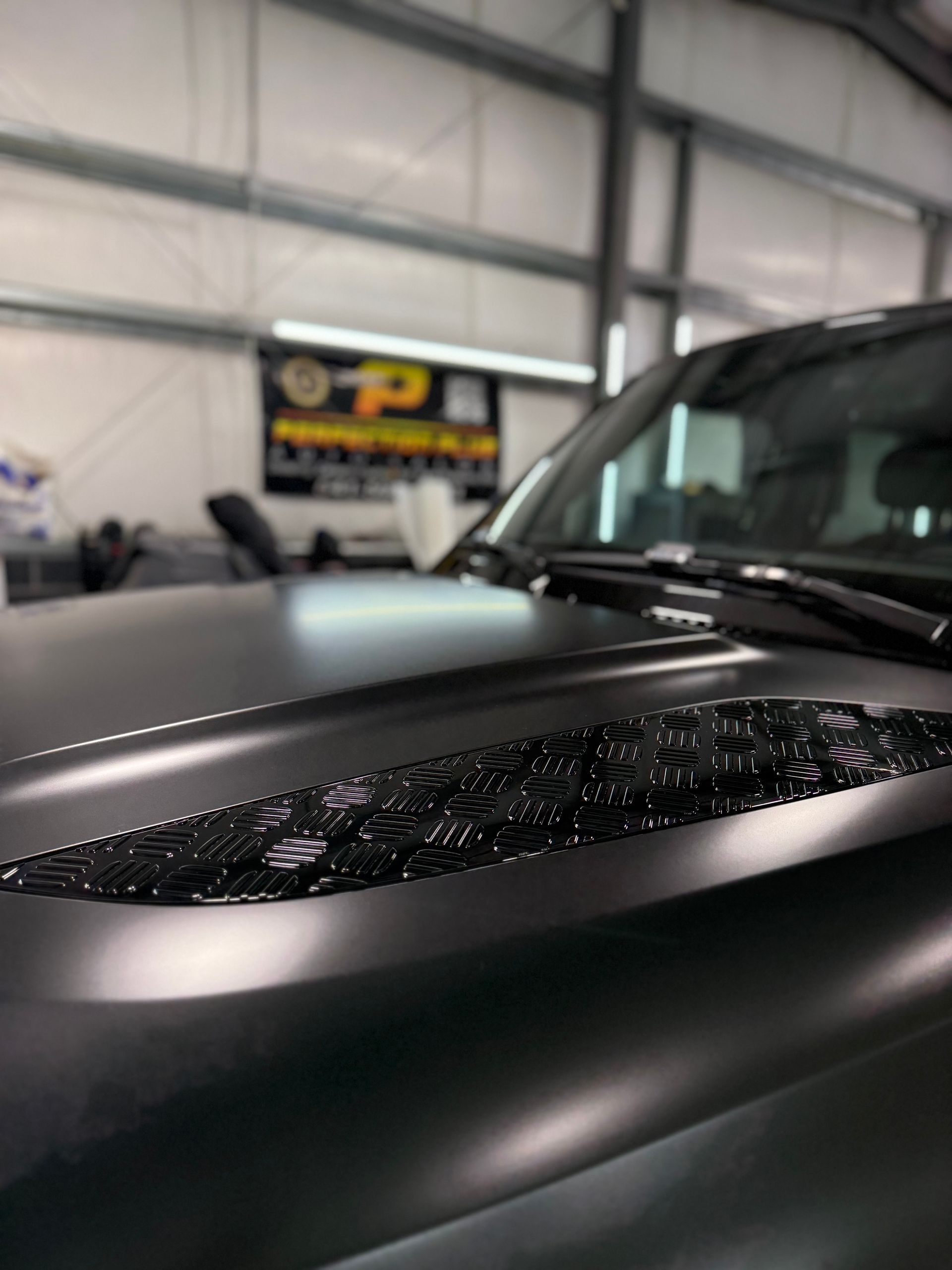 A close up of the hood of a car in a garage