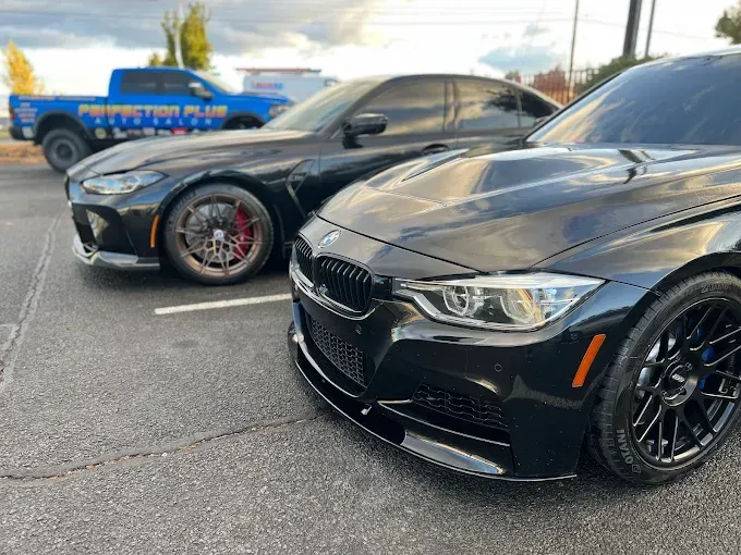 Black BMW and sports car side by side, glossy finish showing ceramic coating protection in Redmon.