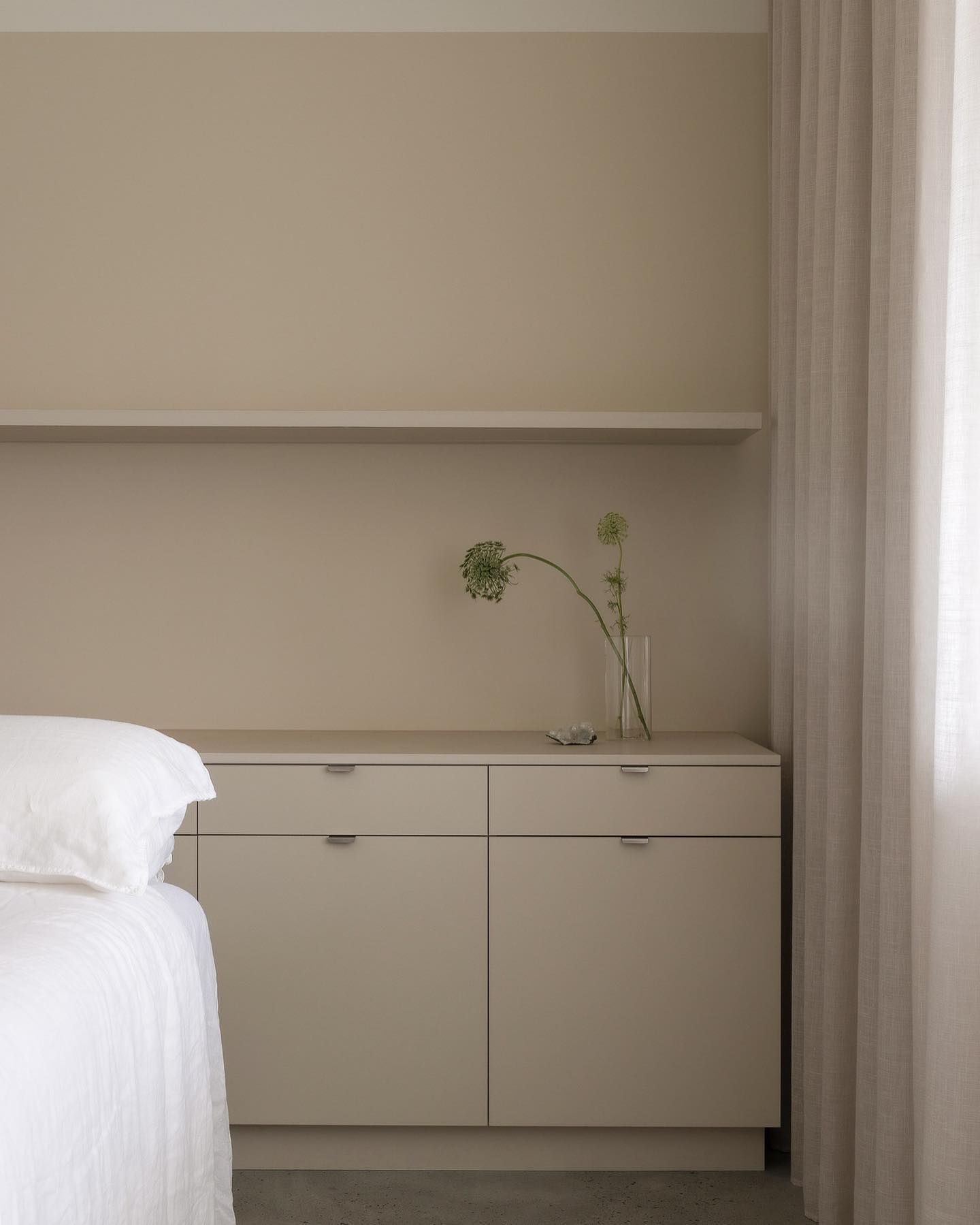 A Bedroom With a Bed and a Dresser With a Vase of Flowers on It — Precision Kitchens & Cabinets in Ballina, NSW