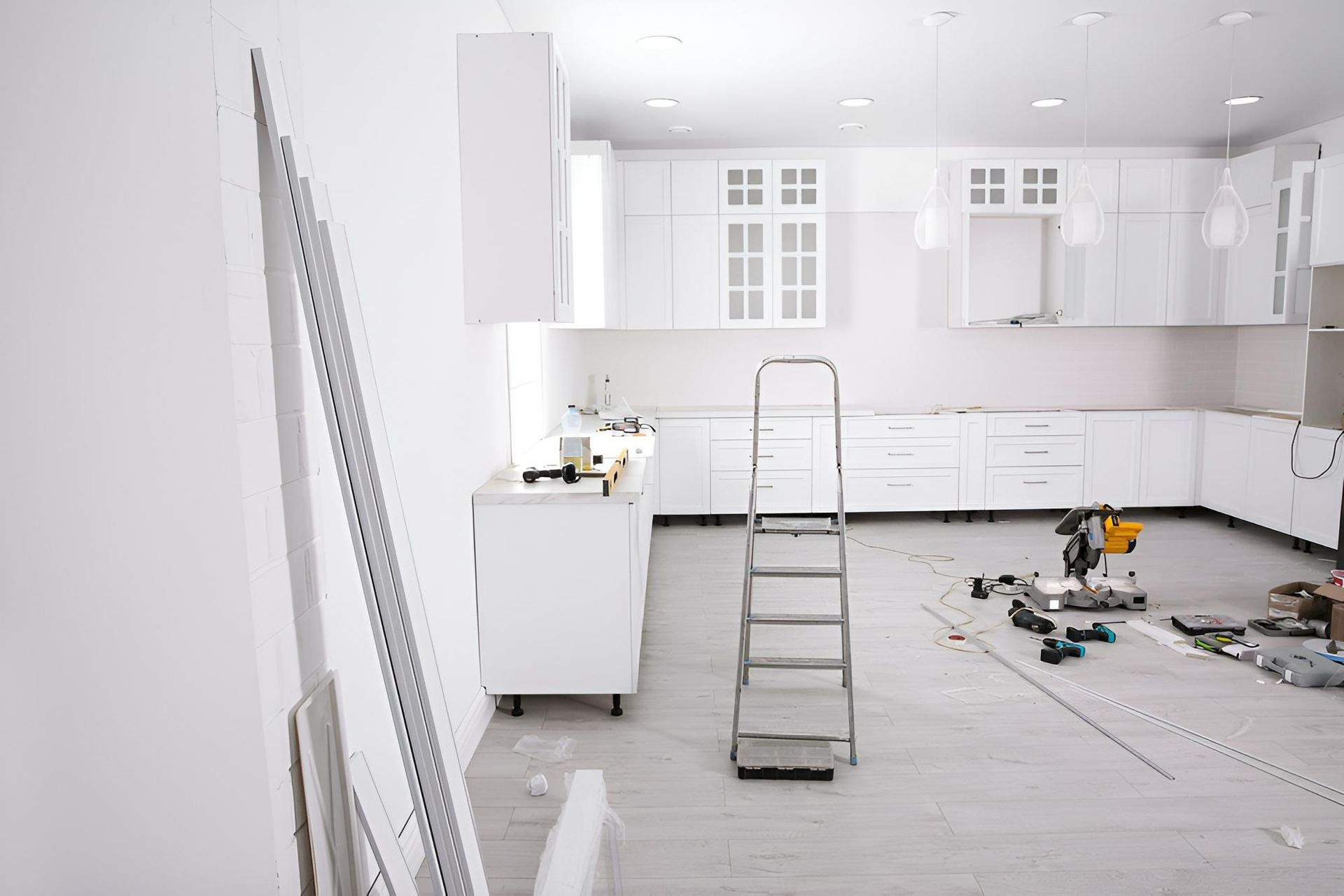 A Kitchen is Being Remodeled With White Cabinets and a Ladder — Precision Kitchens & Cabinets in Ballina, NSW