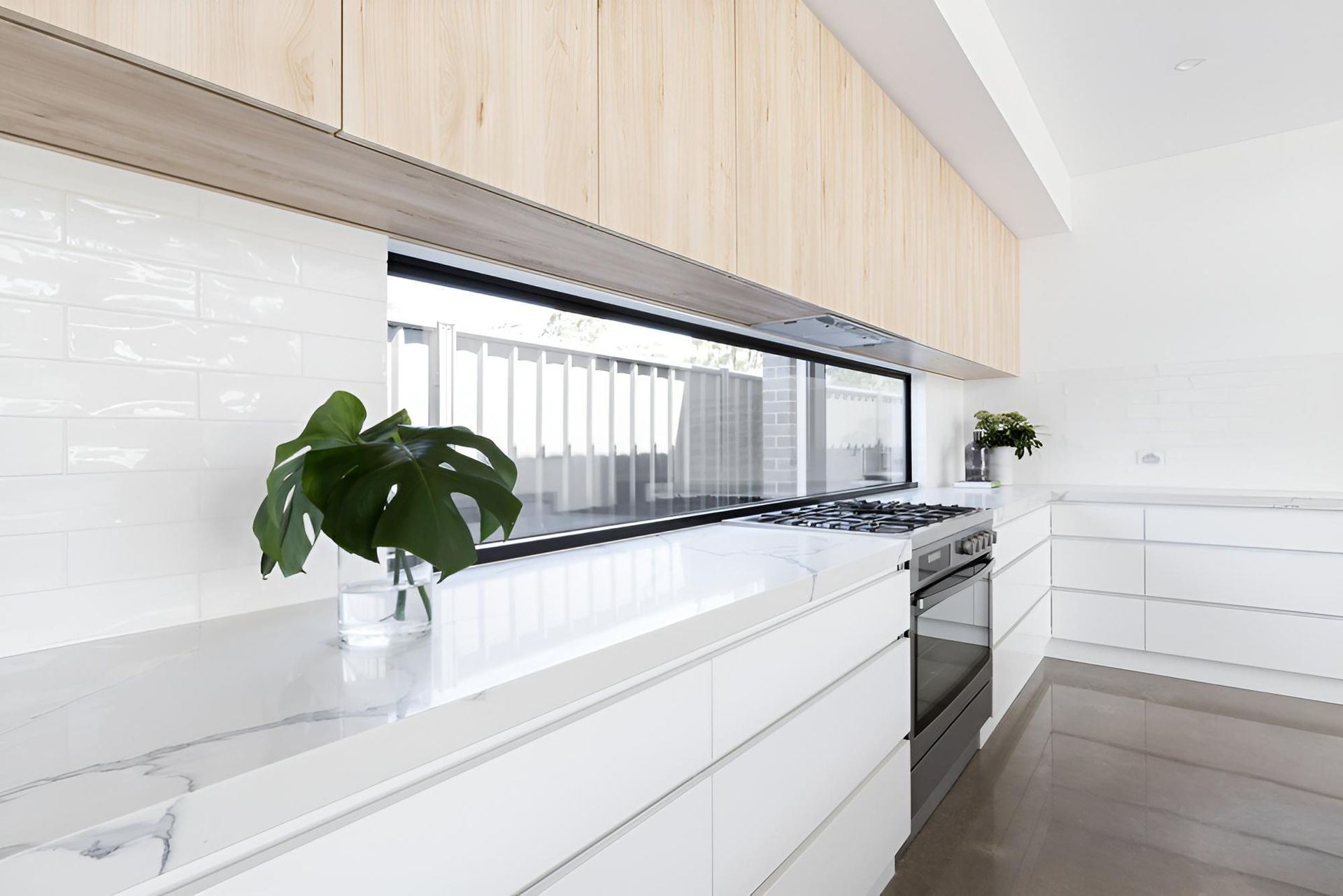 A Kitchen With White Cabinets and a Potted Plant on the Counter — Precision Kitchens & Cabinets in Evans Head, NSW