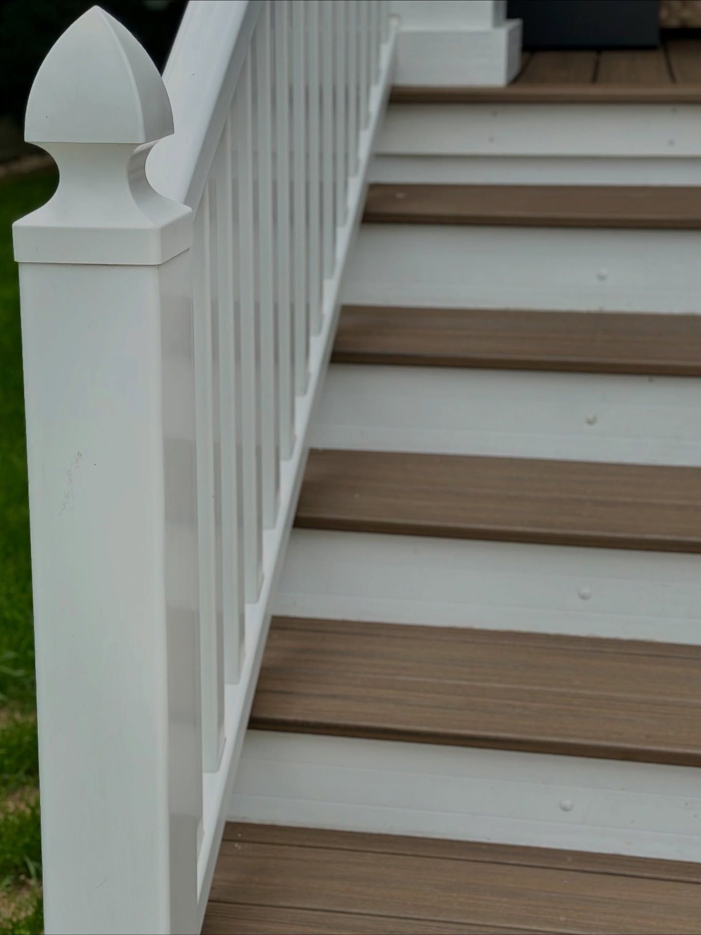 White railing and steps with brown treads.