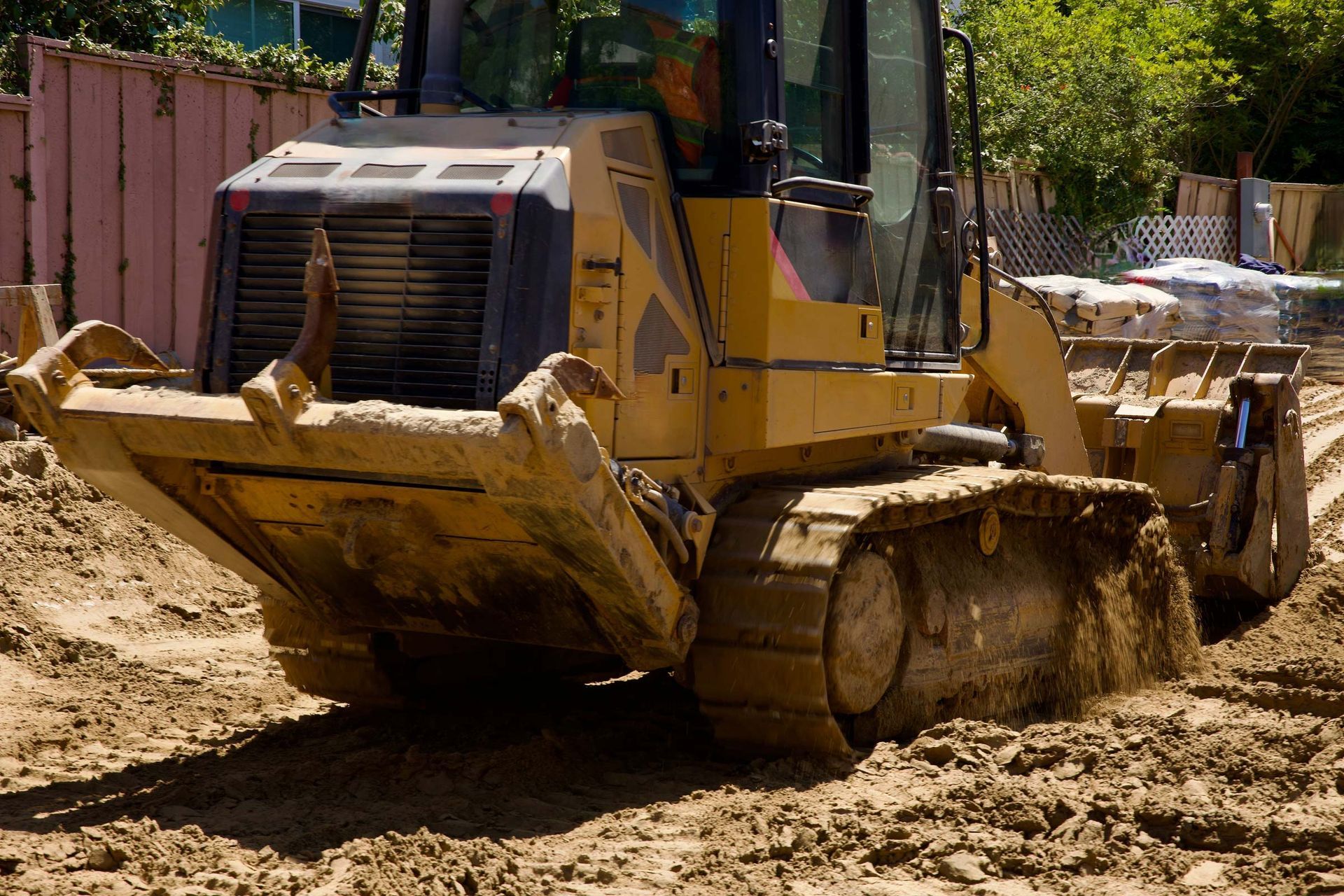 Yellow bulldozer moving dirt at a construction site.
