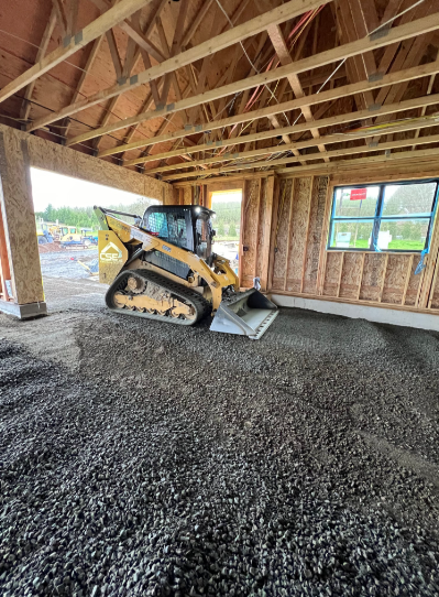 Yellow bulldozer pushing earth on a construction site; blue sky in the background.