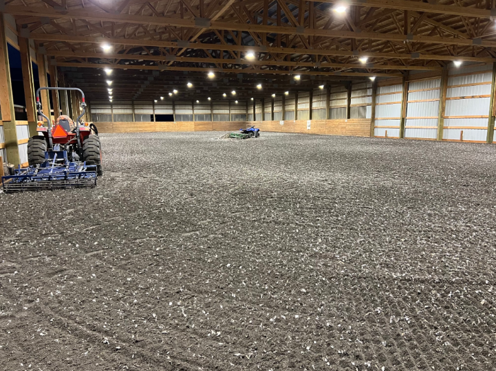 Yellow excavator on a construction site digging dirt under a bright blue sky.