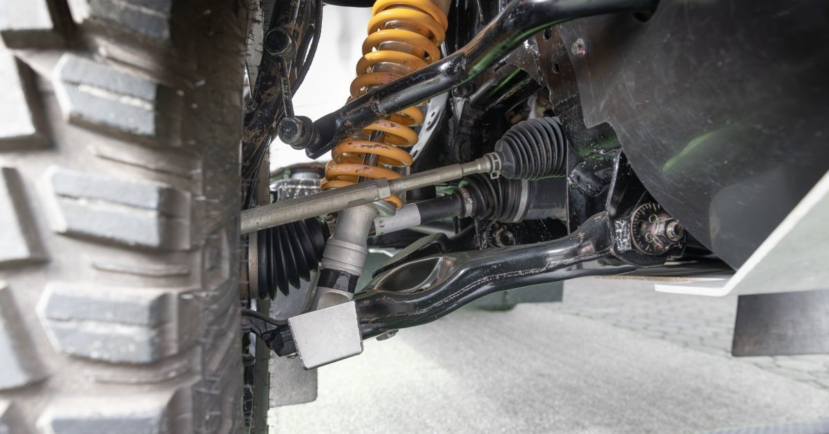 A close-up of an off-road car's suspension system and its components.
