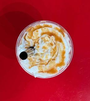 A cup of coffee is sitting on a red table.