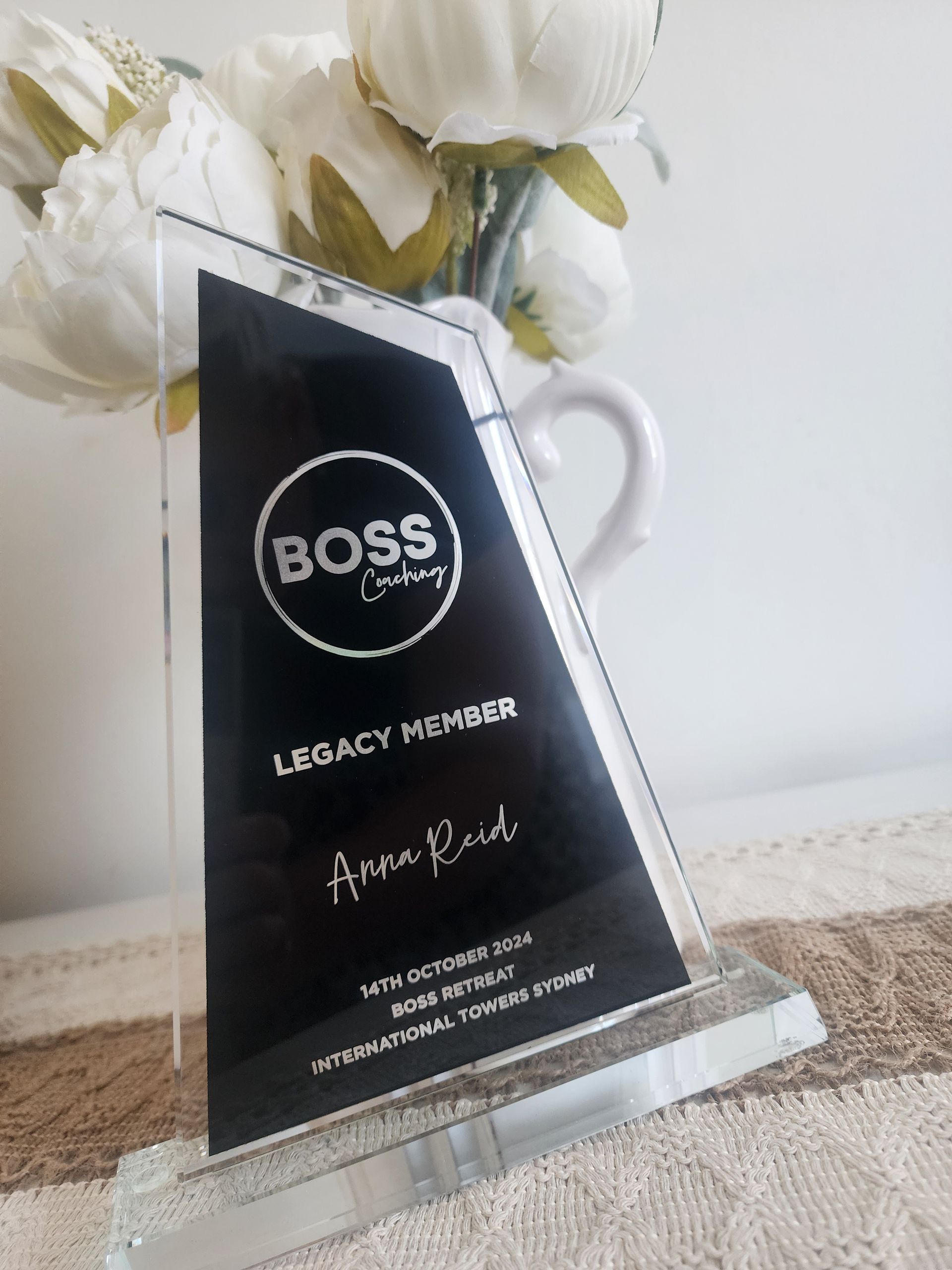 A glass trophy with the word boss on it