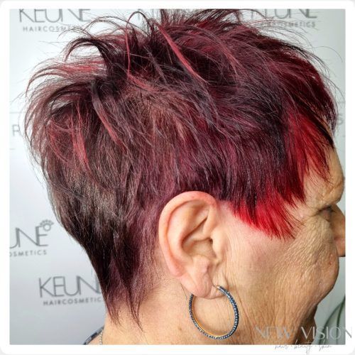 A woman with short red hair is wearing hoop earrings