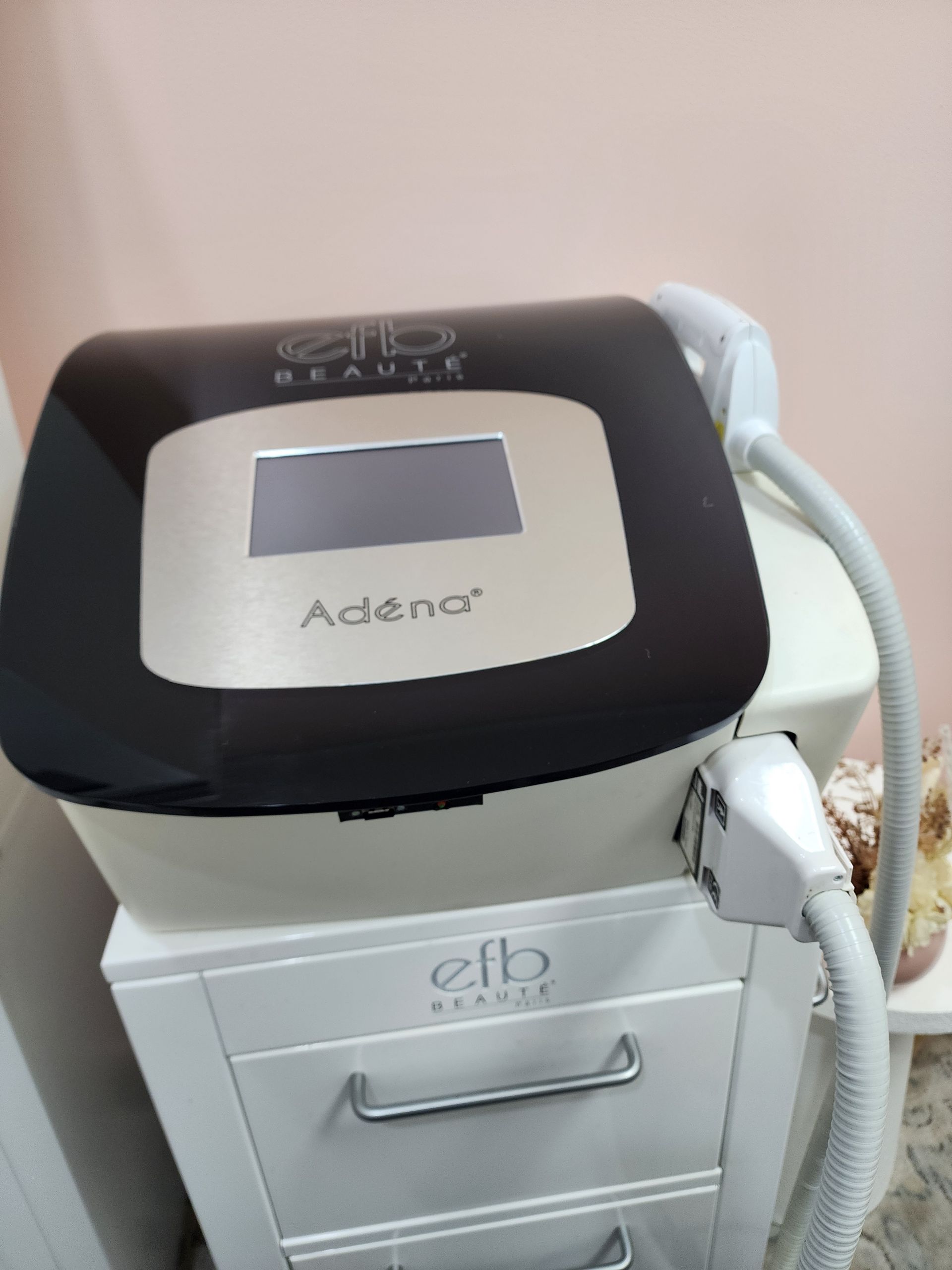 A woman wearing sunglasses is using a machine that says ' laser ' on it