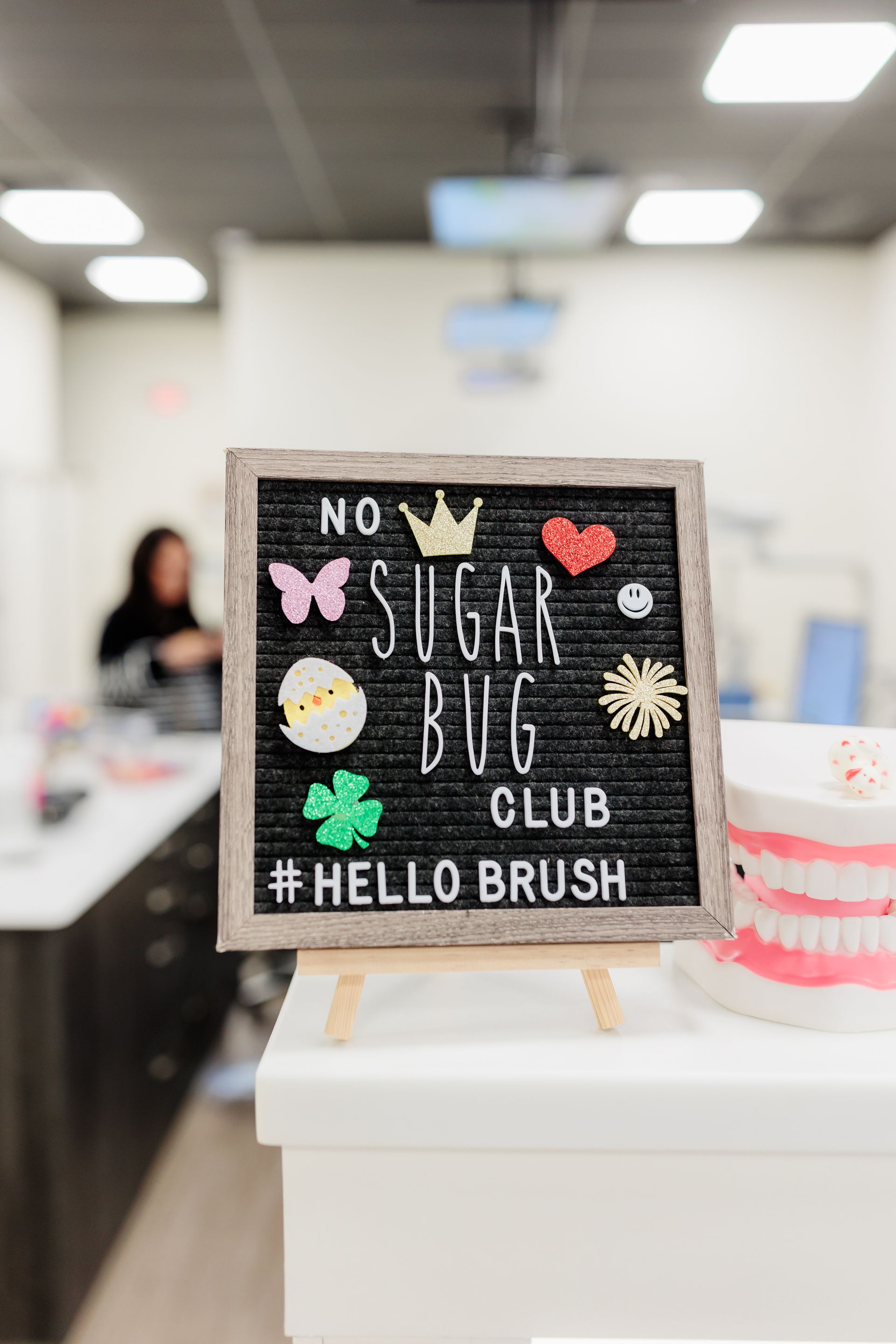 A sign that says `` no sugar bug club '' is on a table in a dental office.