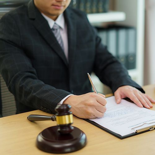 Lawyer Holding Pen and Signing Document — Newport Beach, CA — Paoli & Purdy, PC