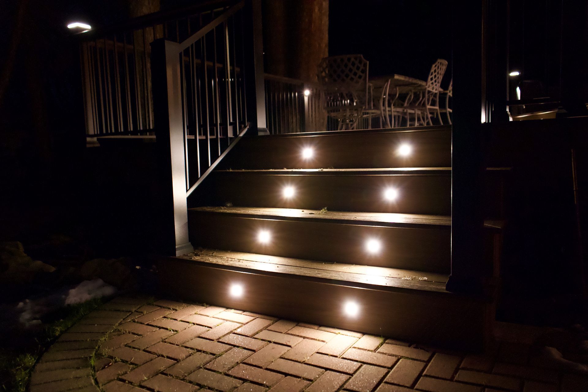 A deck with stairs that are lit up at night.