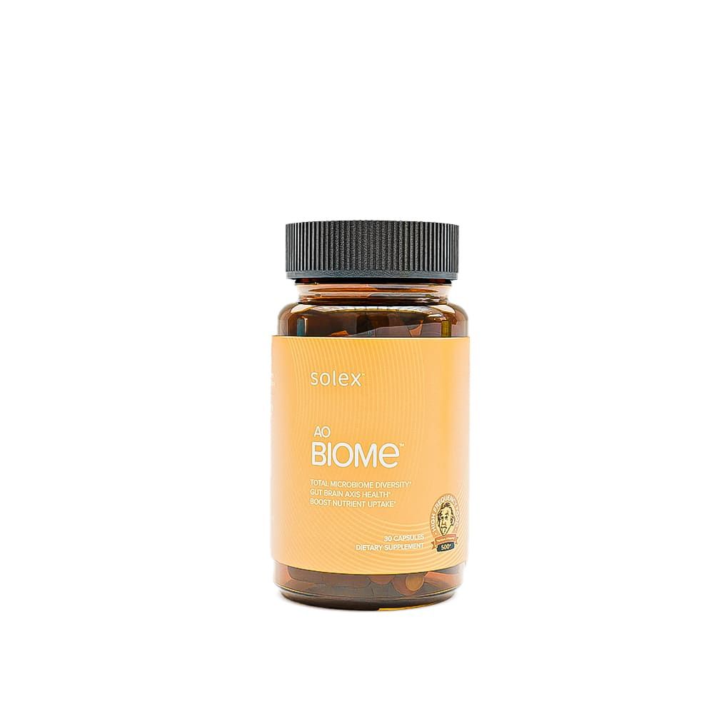 Bottle of "Biome" supplements with yellow label, black cap, isolated on white.