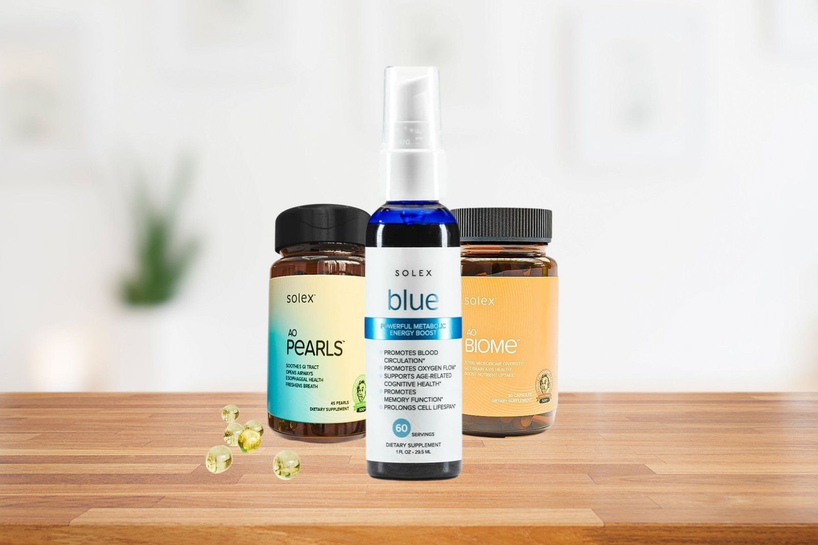 Three health supplement bottles on a wooden surface: spray bottle in the center, capsules to each side.