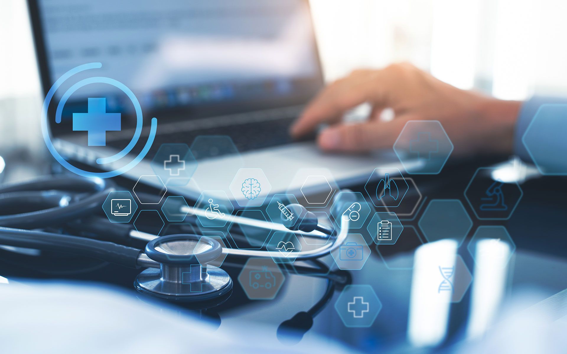 Doctor using a laptop with stethoscope, healthcare icons overlayed.