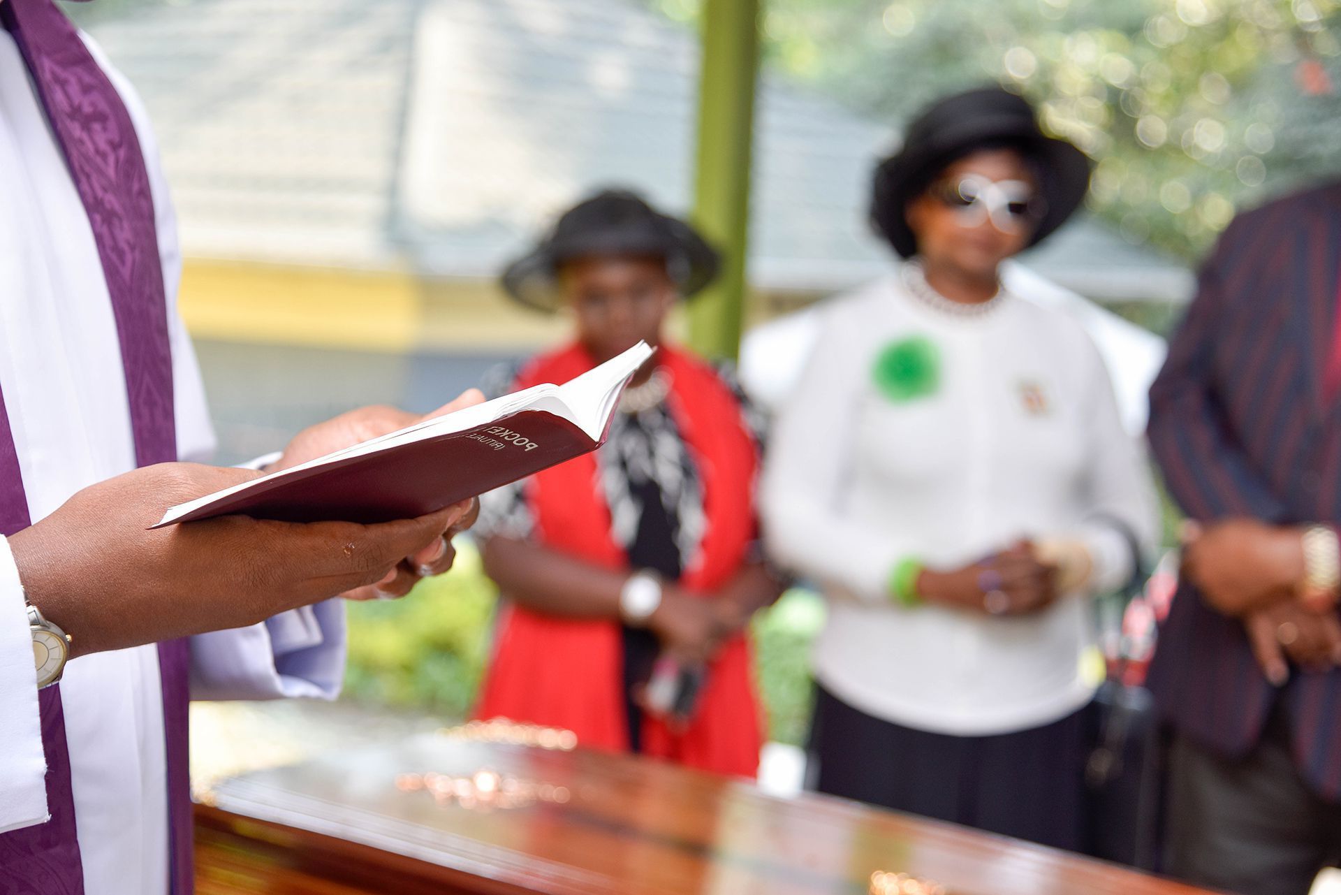 person reading from a book during a funeral