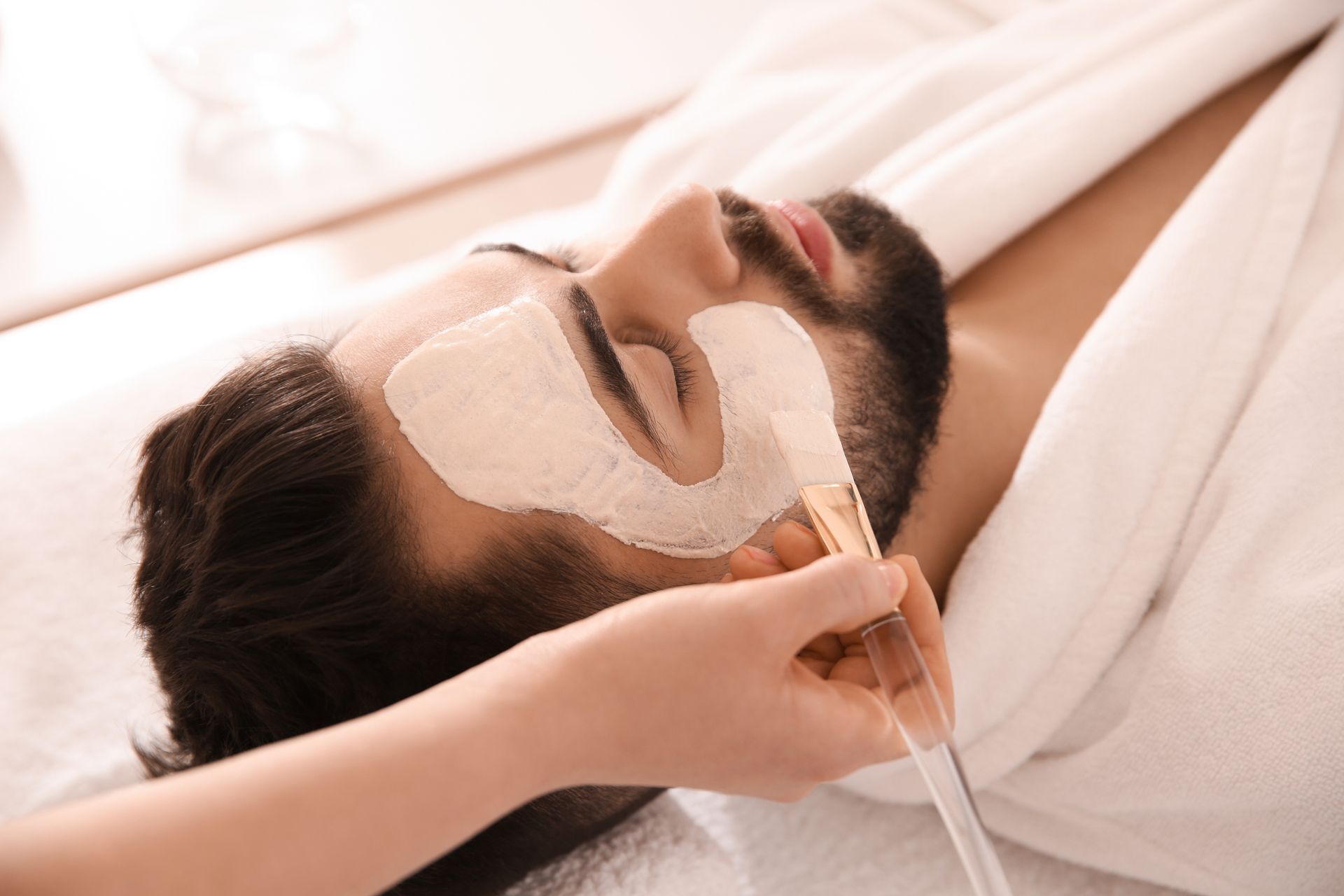 Person receiving a facial treatment with a mask applied under their eyes, at a spa.