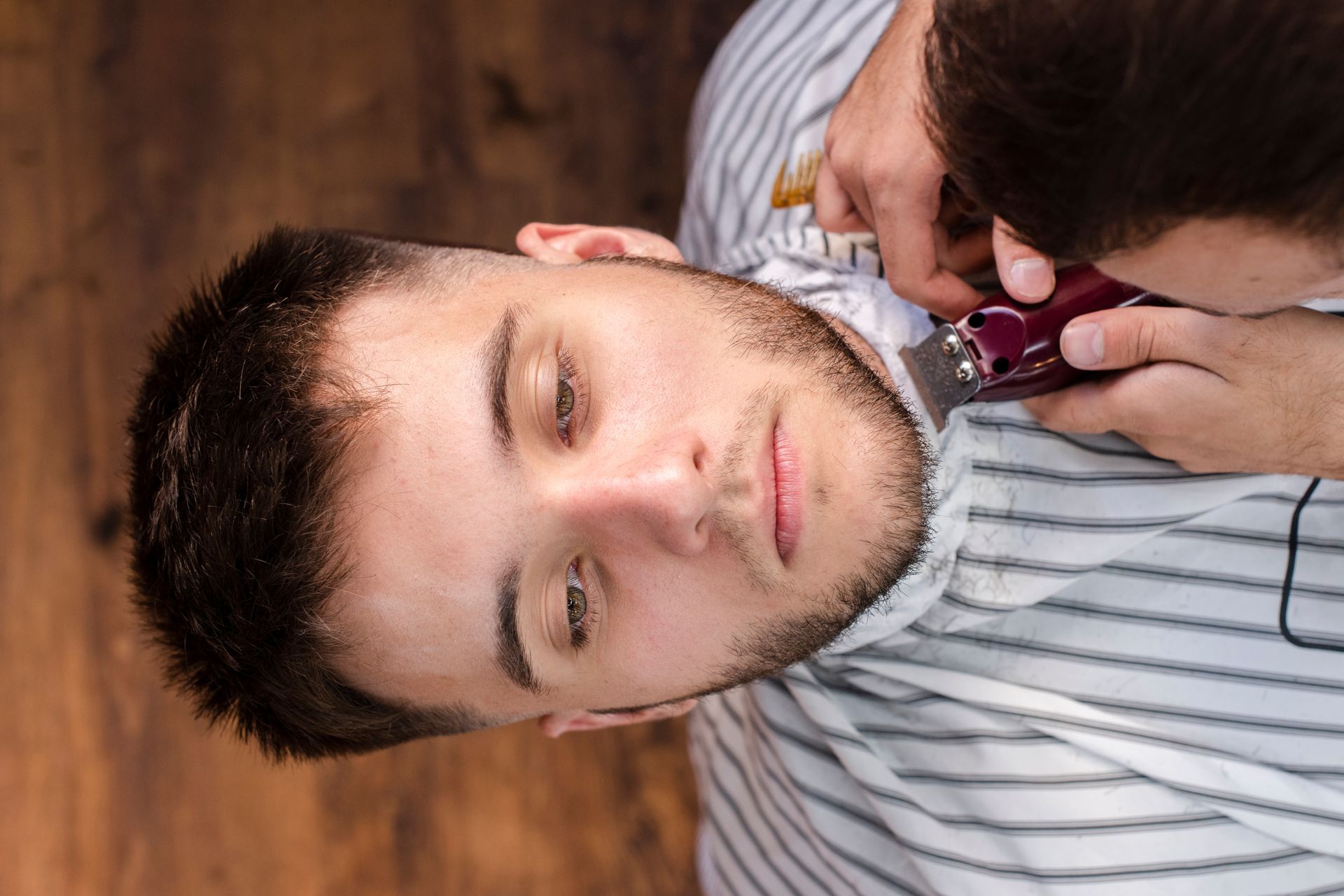 A man is getting his beard cut by a barber.