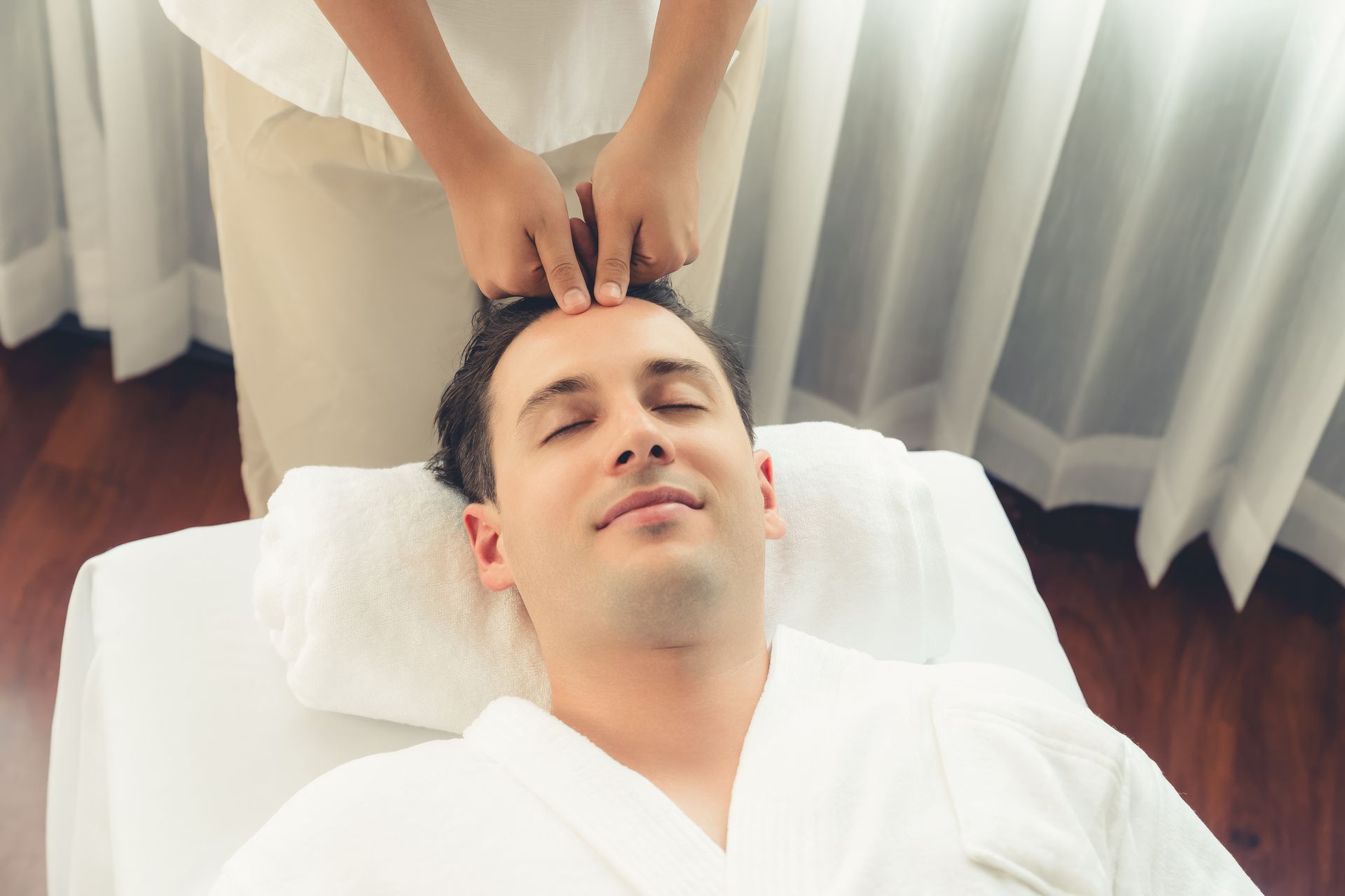 A man is getting a head massage at a spa.
