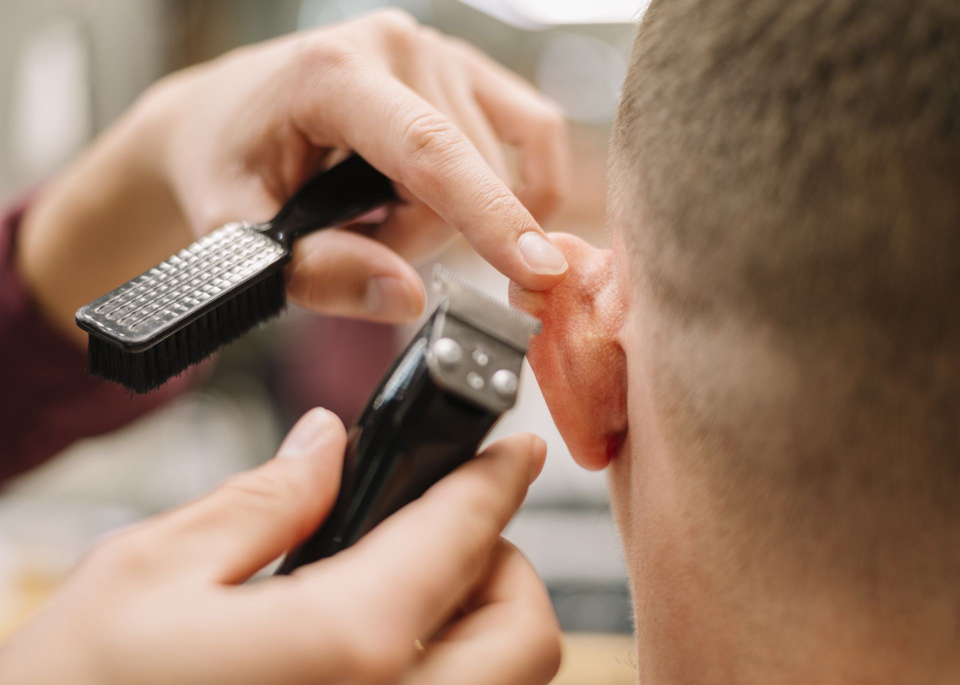 A man is getting his hair cut by a barber.