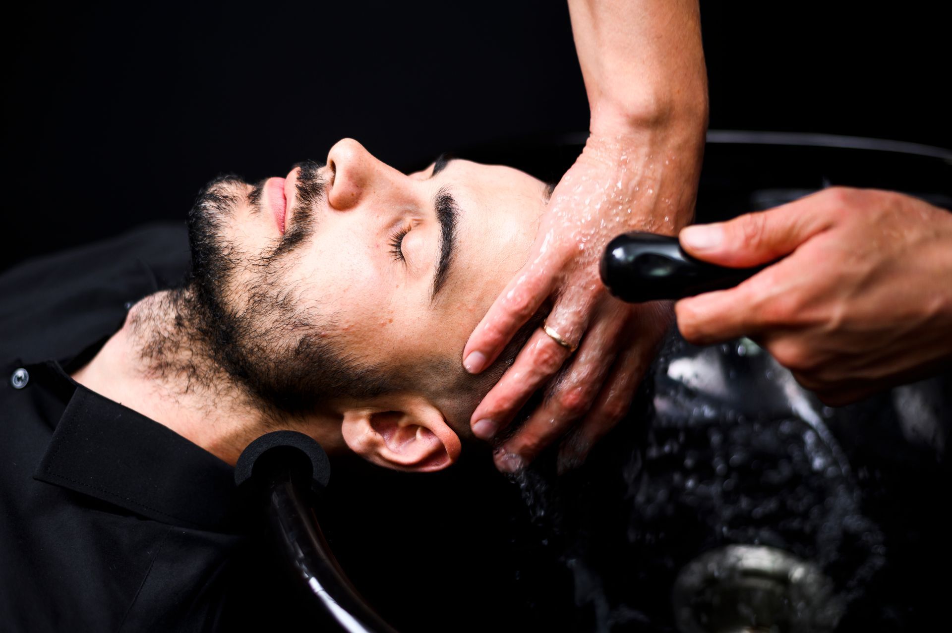 A man is getting his hair washed at a salon.