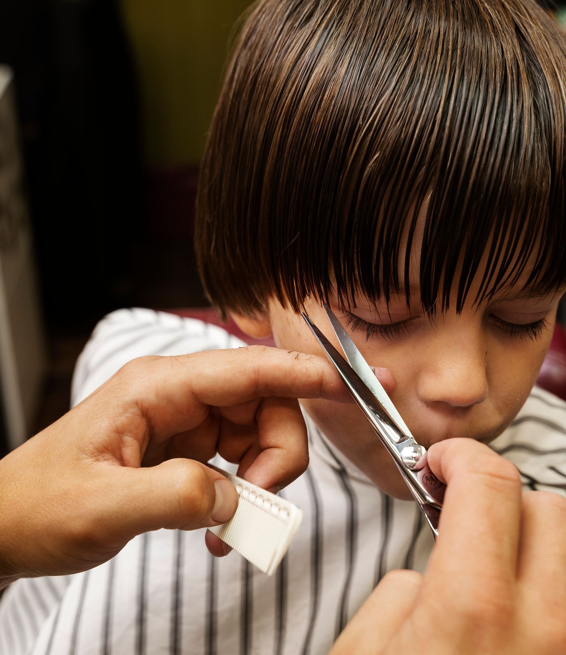 A man is getting his beard shaved at a barber shop.