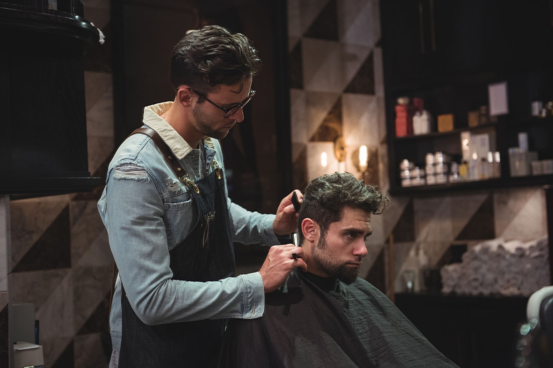 A man is getting his hair cut by a barber in a barber shop.