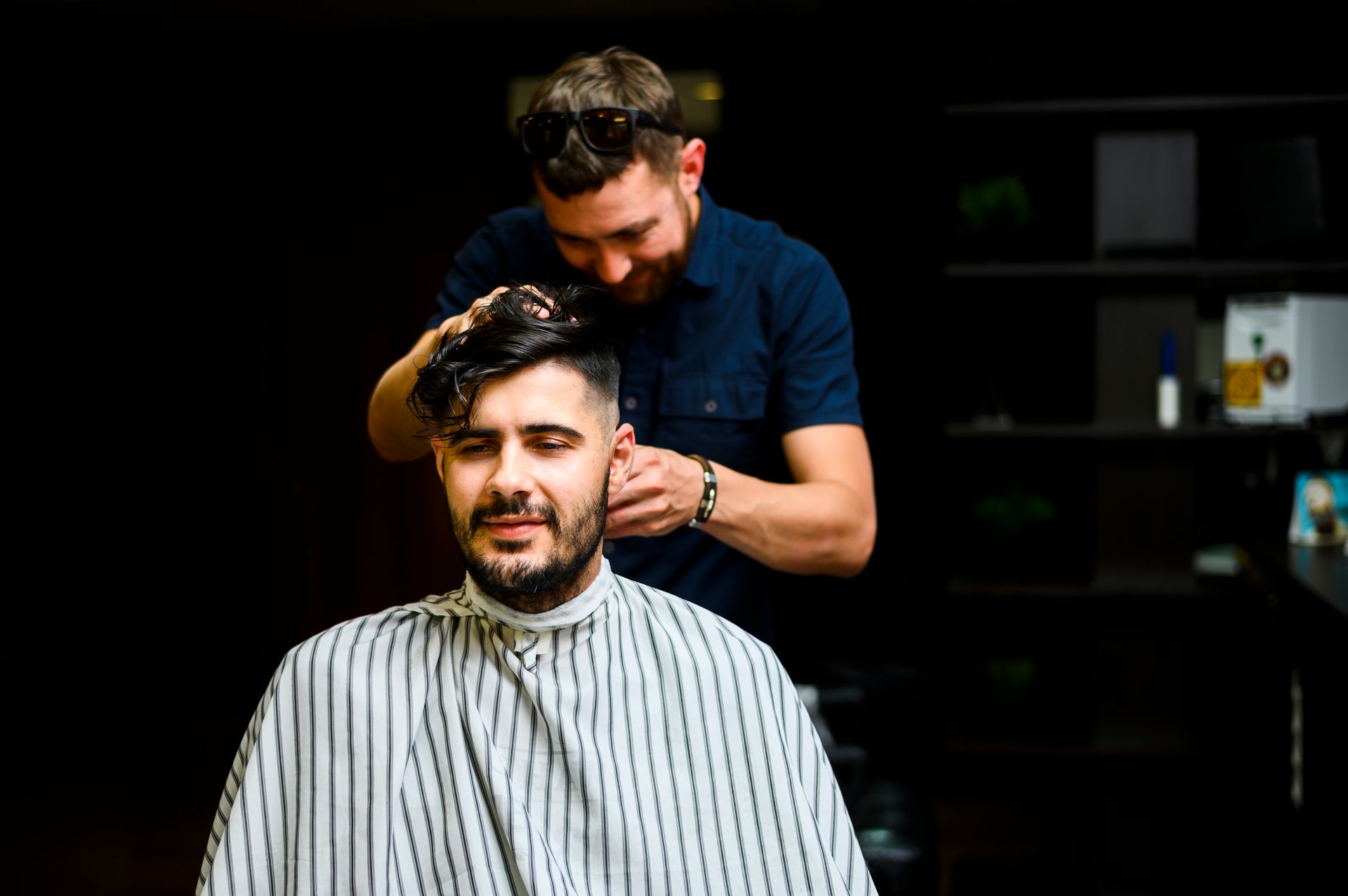 A man is getting his hair cut by a barber in a barber shop.