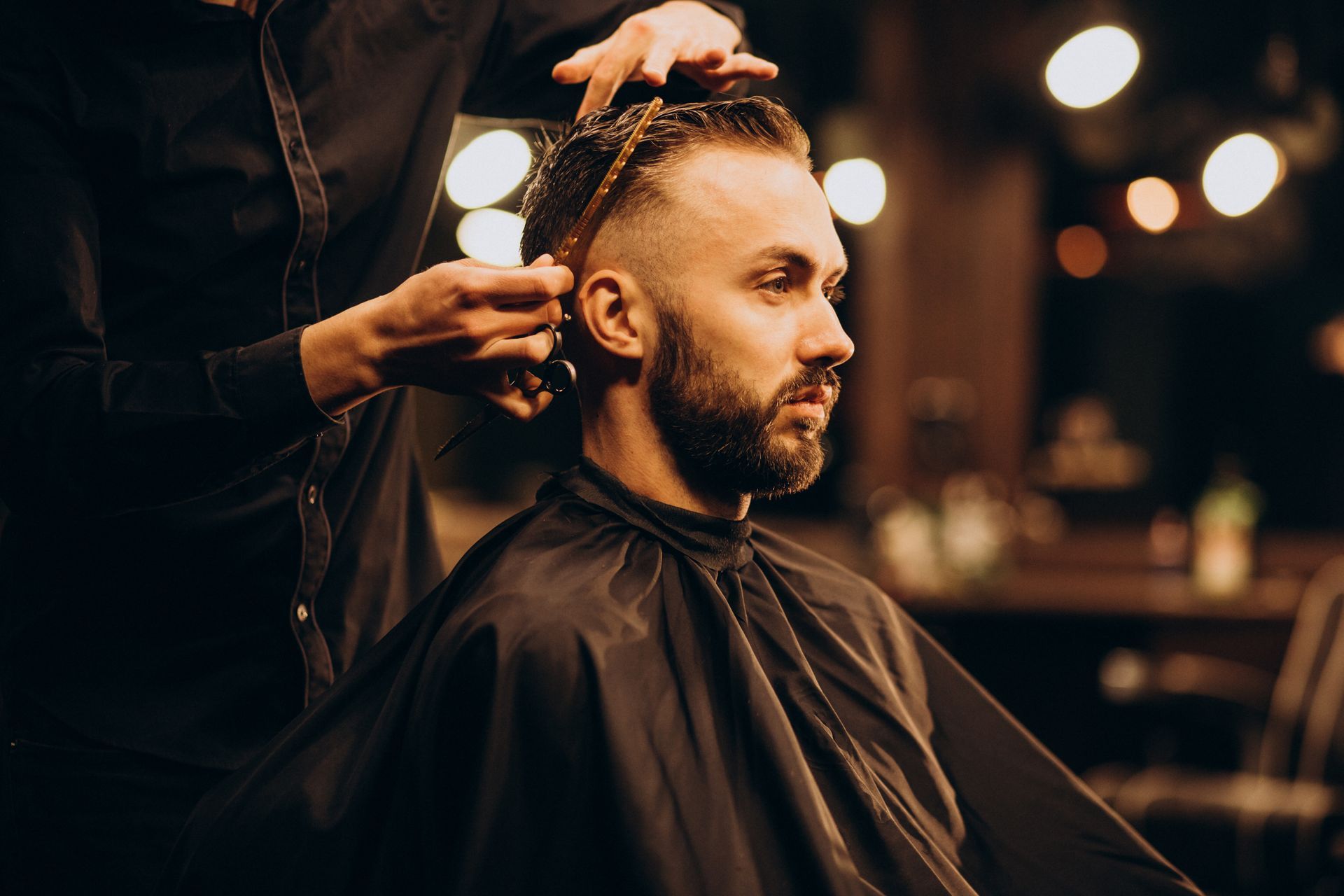 A man is getting his hair cut by a barber in a barber shop.