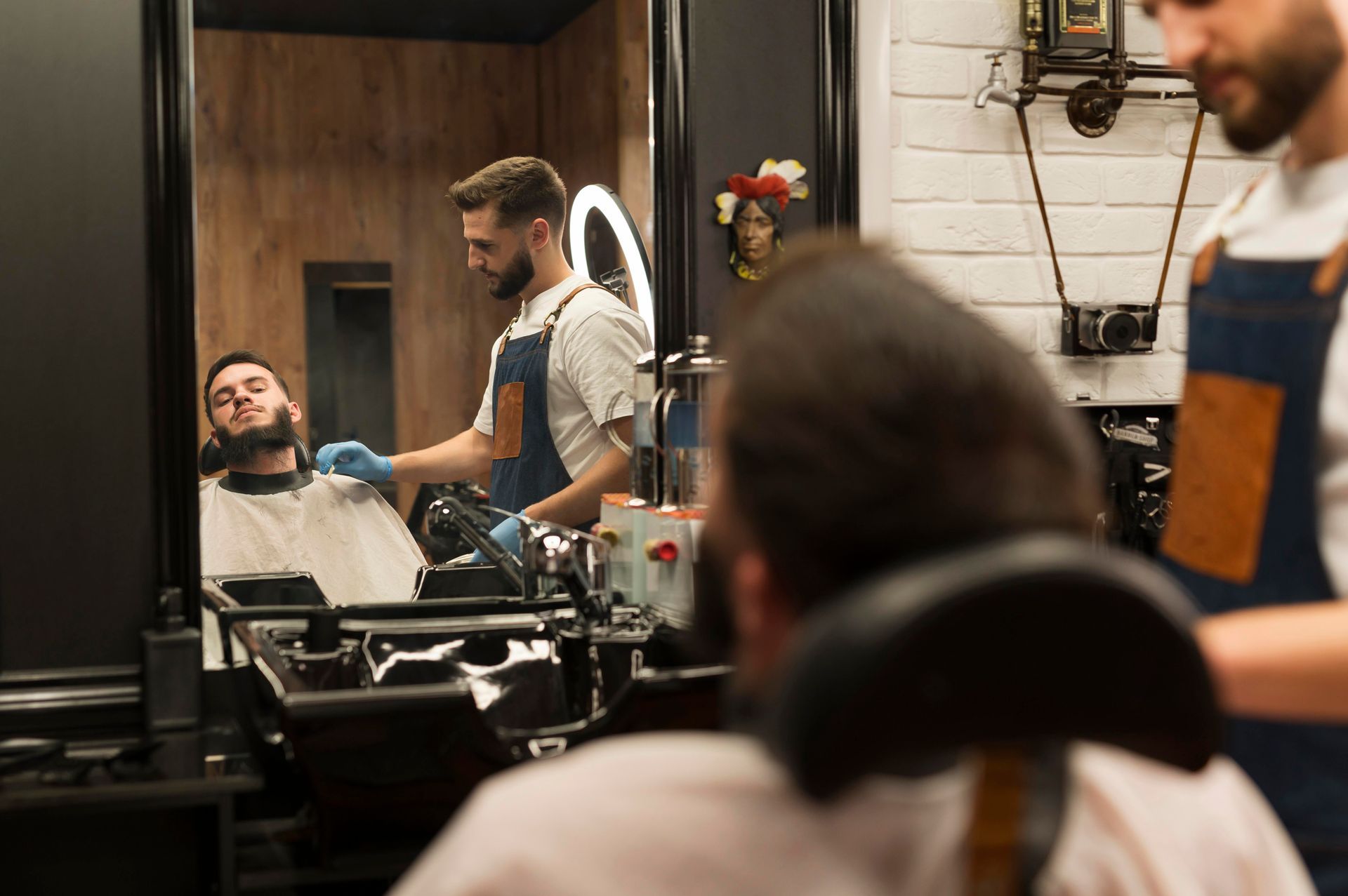 A man is getting his hair cut by a barber in a barber shop.
