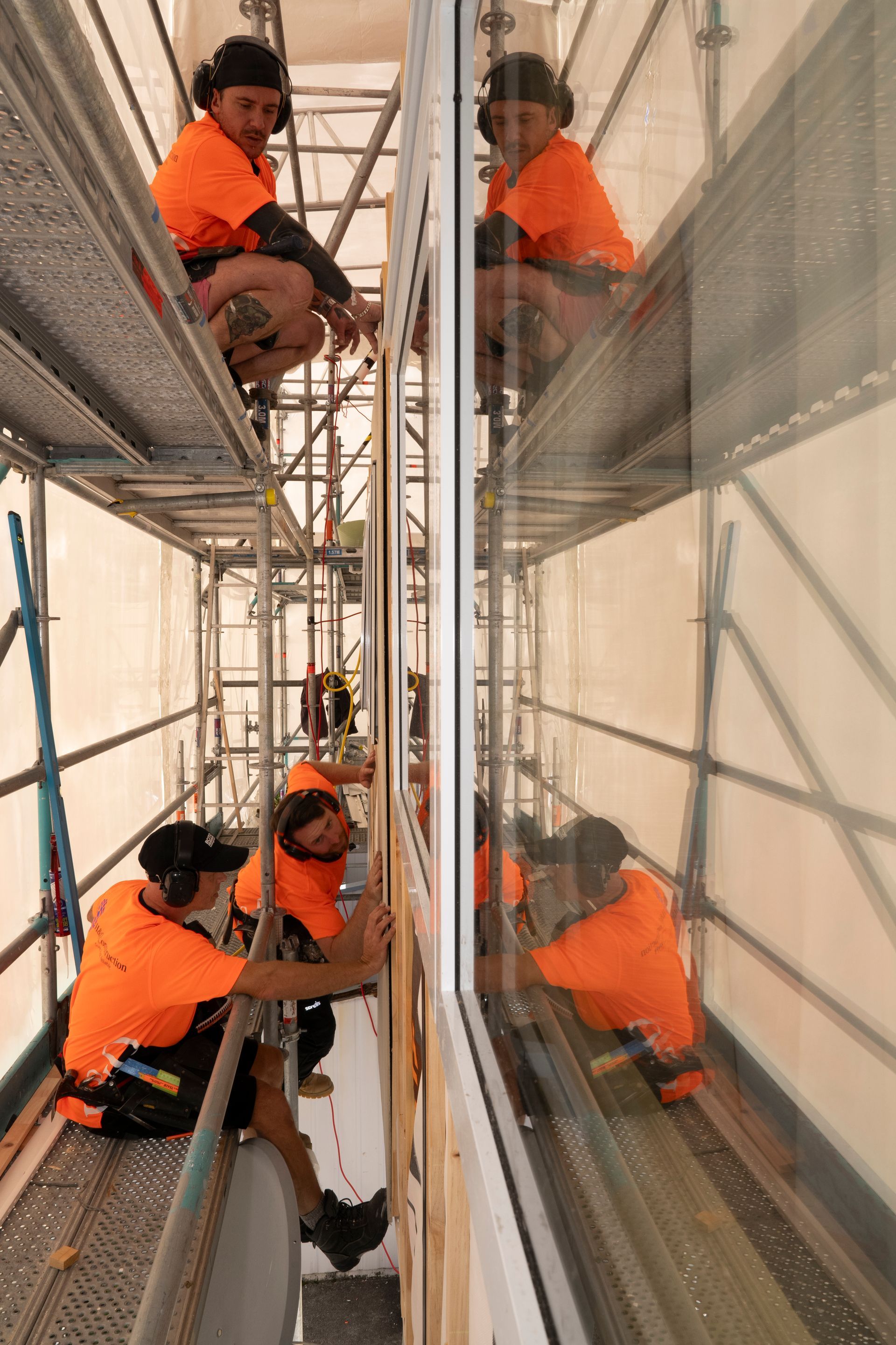 A group of construction workers are working on a building on scaffolding.