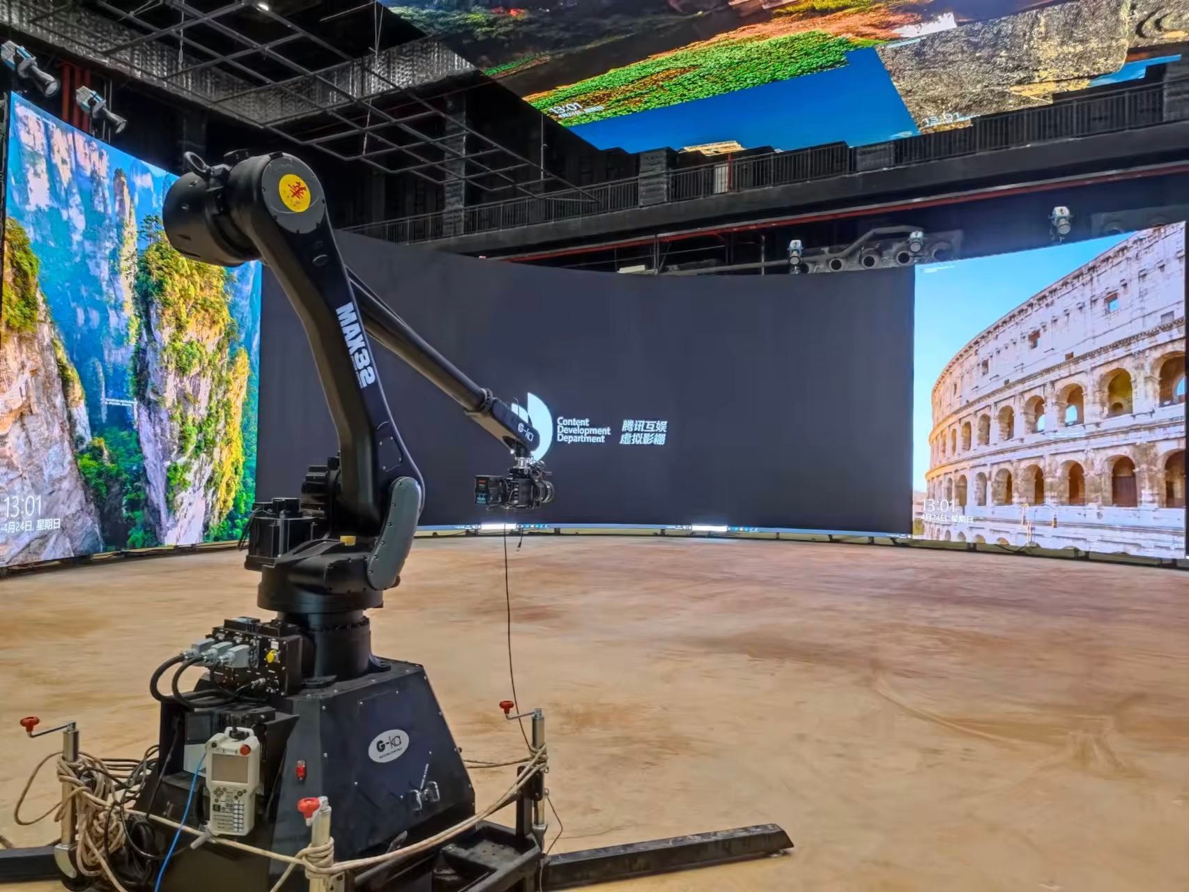 G-ka motion control robotic arm is sitting in front of a large screen.