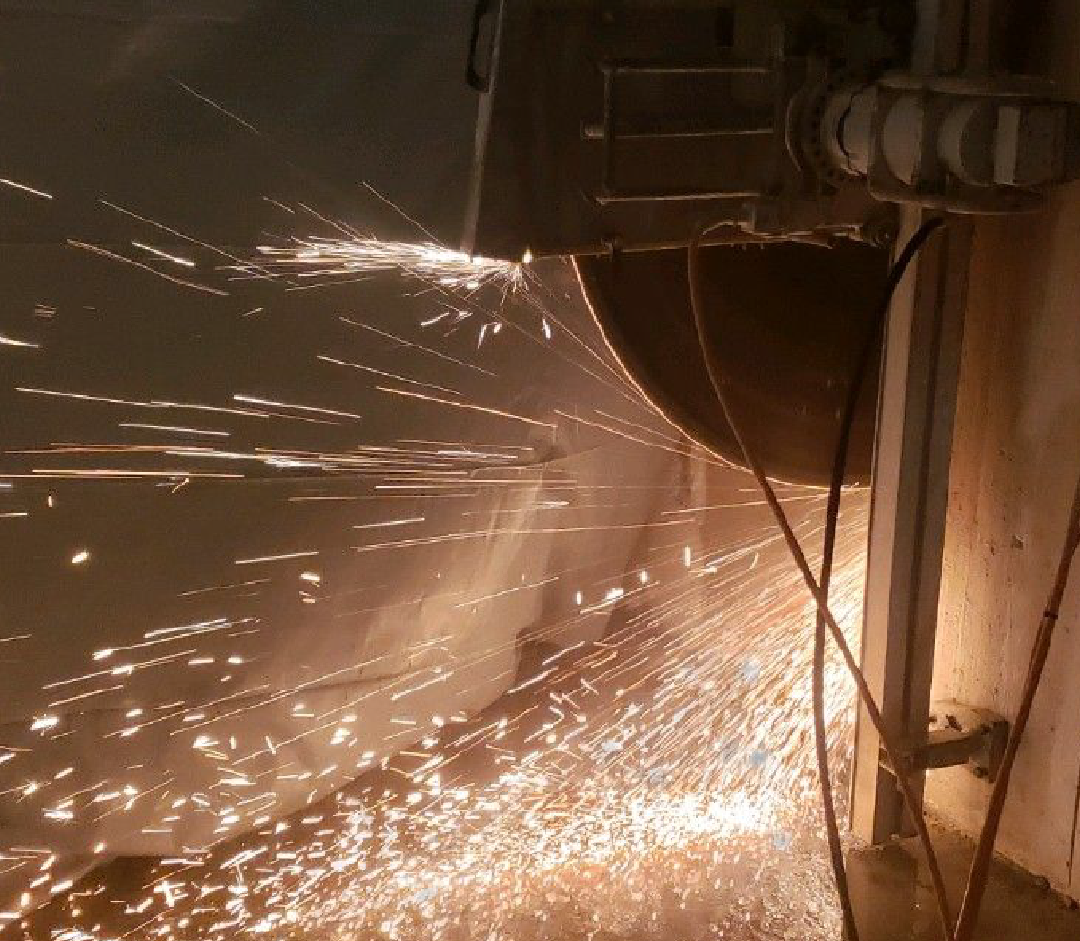 A machine is cutting concrete with sparks coming out of it.