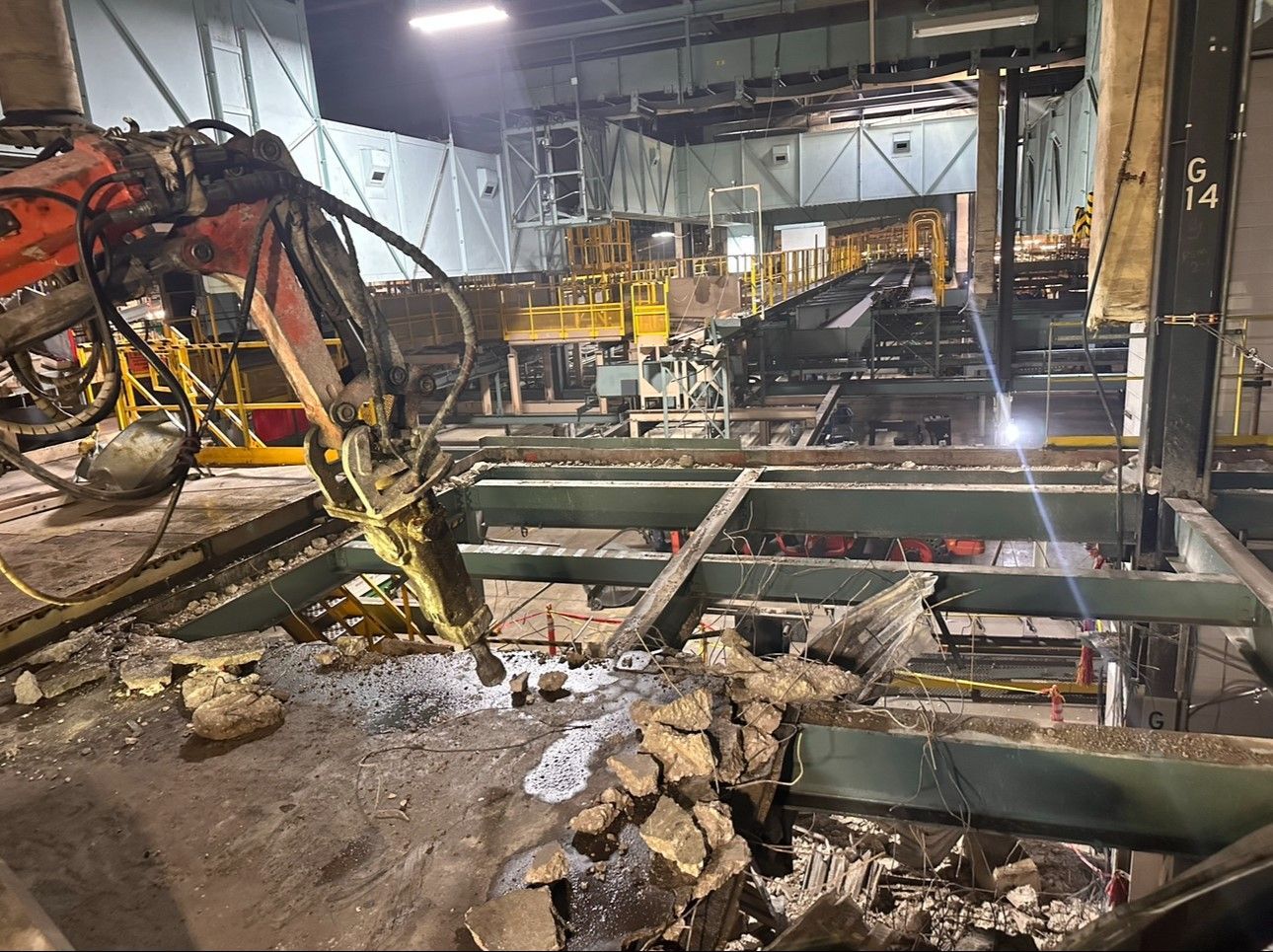 A robotic concrete demolition machine is breaking up concrete in a factory.