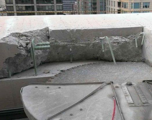 A concrete cutting wall saw is cutting a piece of concrete.