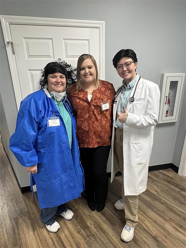 A group of three people standing next to each other in a room.