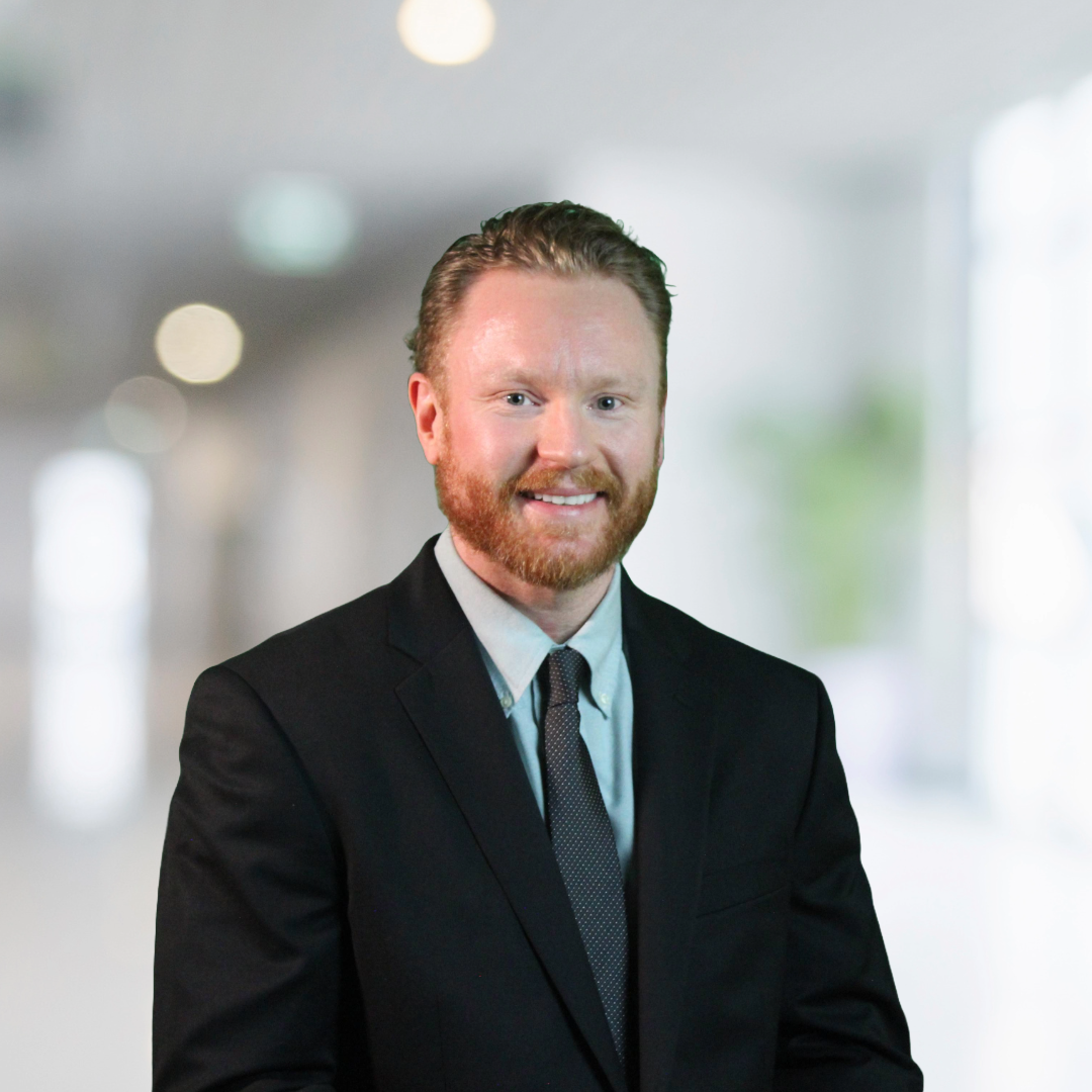 A man in a suit and tie is smiling for the camera
