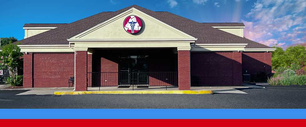 A brick building with a white roof and a red white and blue banner.