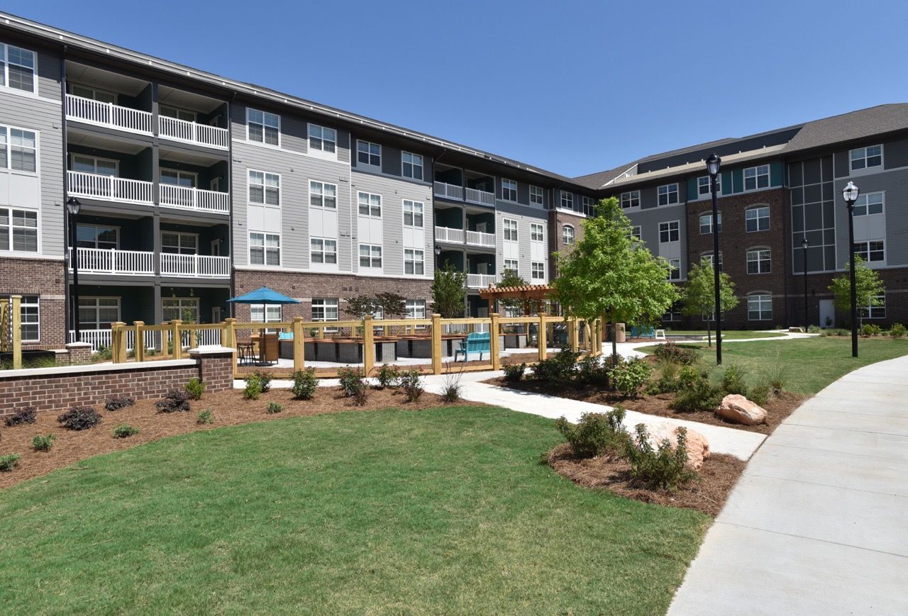 Exterior view of a multi-building apartment complex with a landscaped courtyard.