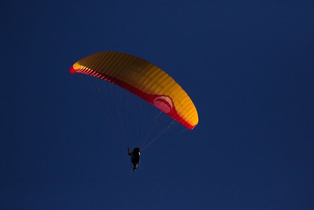 Blauer Himmel mit Paraglide in gelb und rot