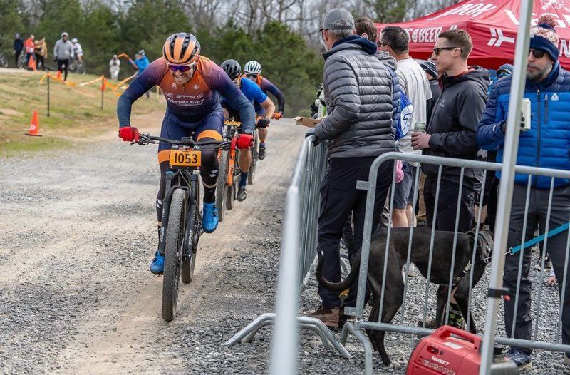 A group of people are riding bicycles down a dirt road.