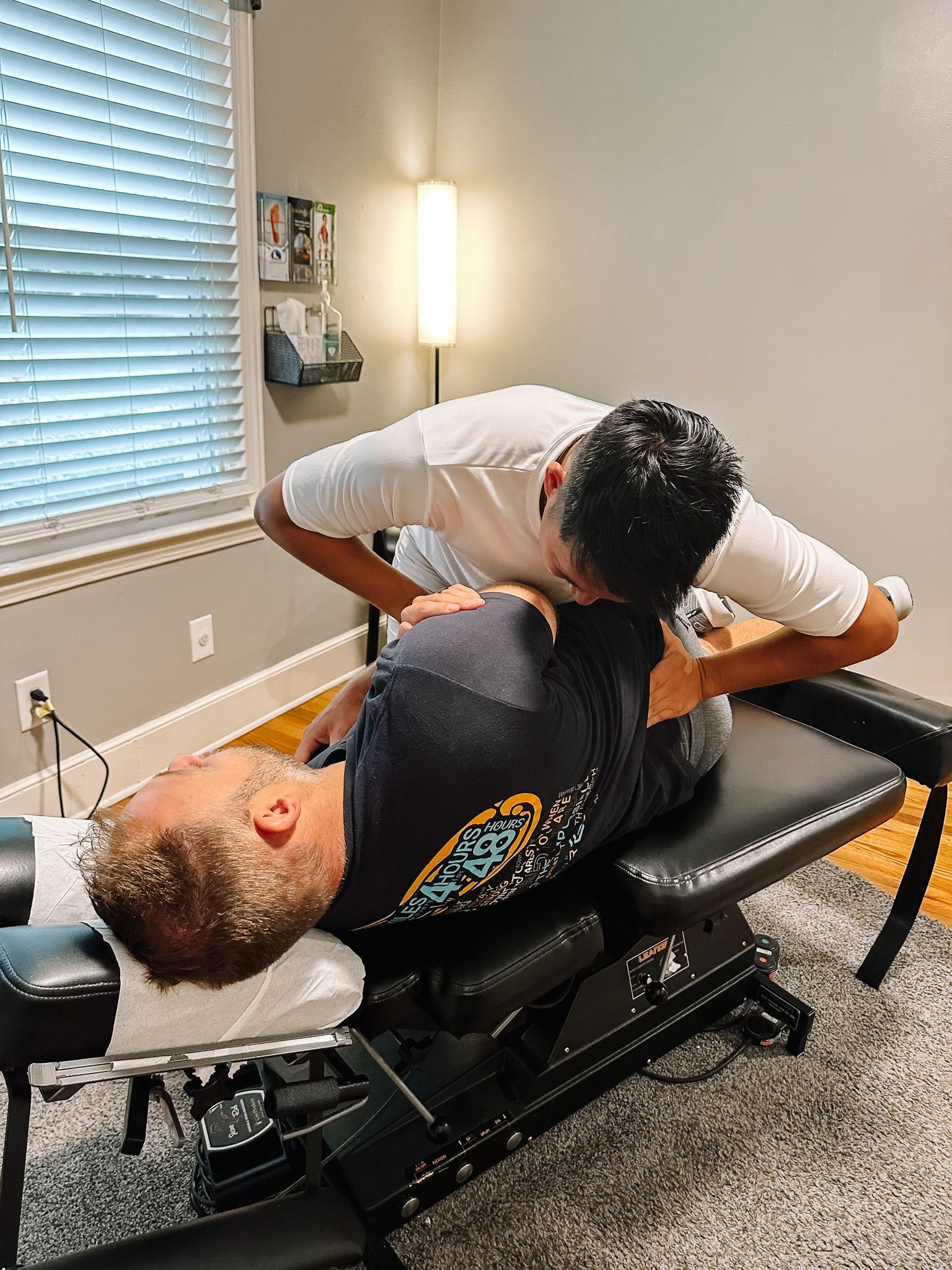 A man is laying on a table getting a chiropractic treatment.