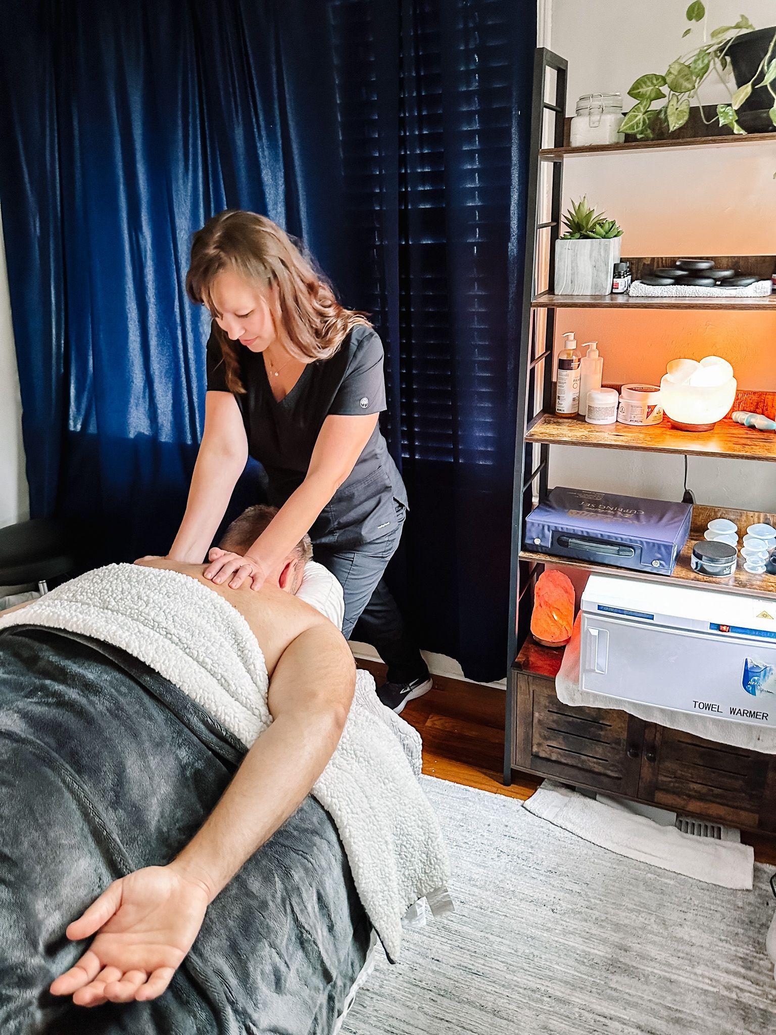 A woman is giving a man a massage in a room.