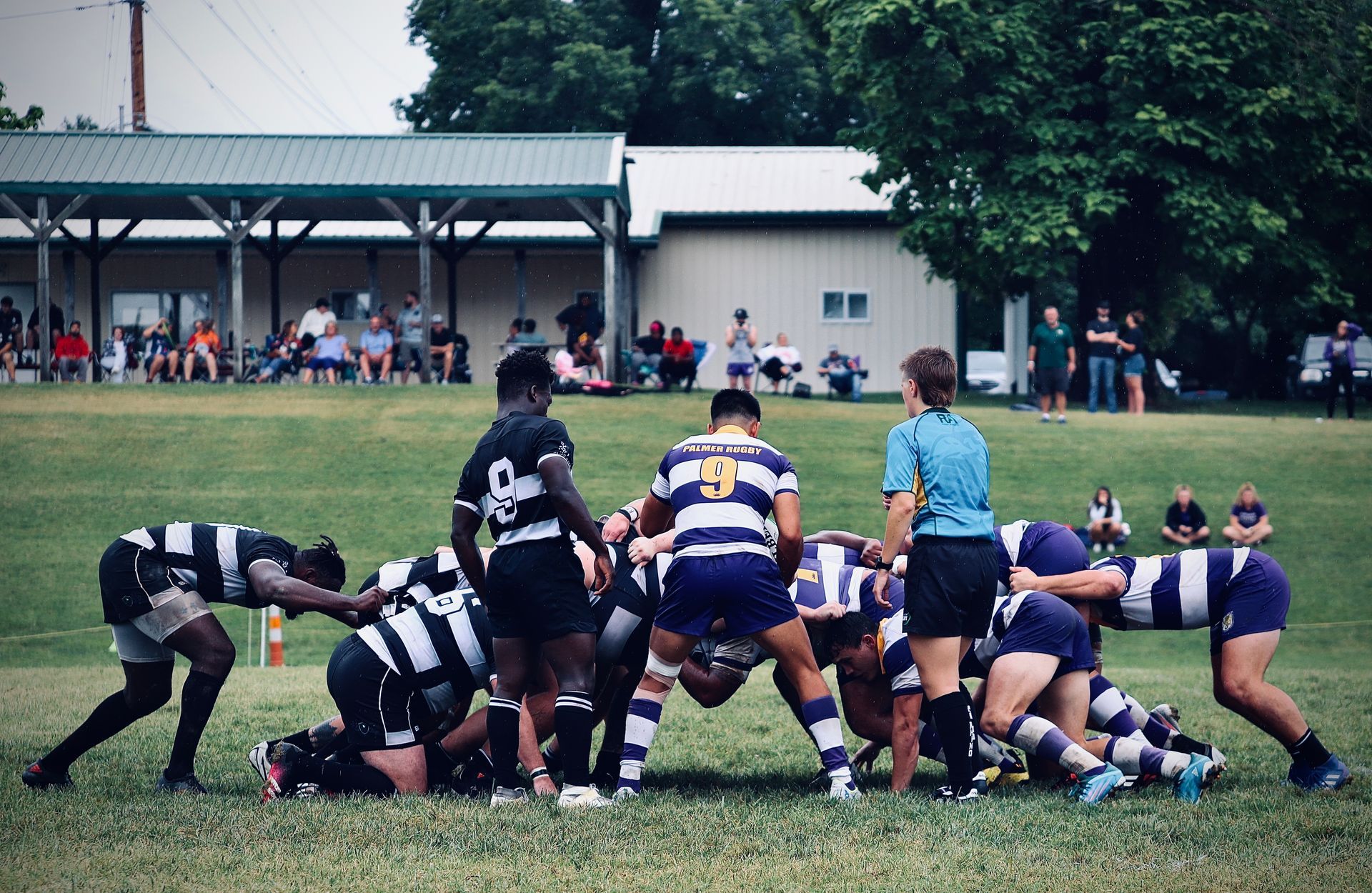 A group of people are playing rugby on a field.