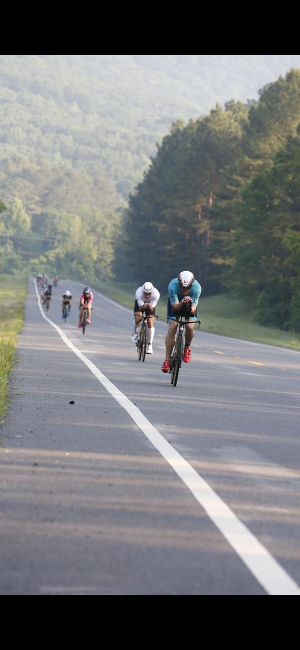 A group of people are riding bikes down a road.